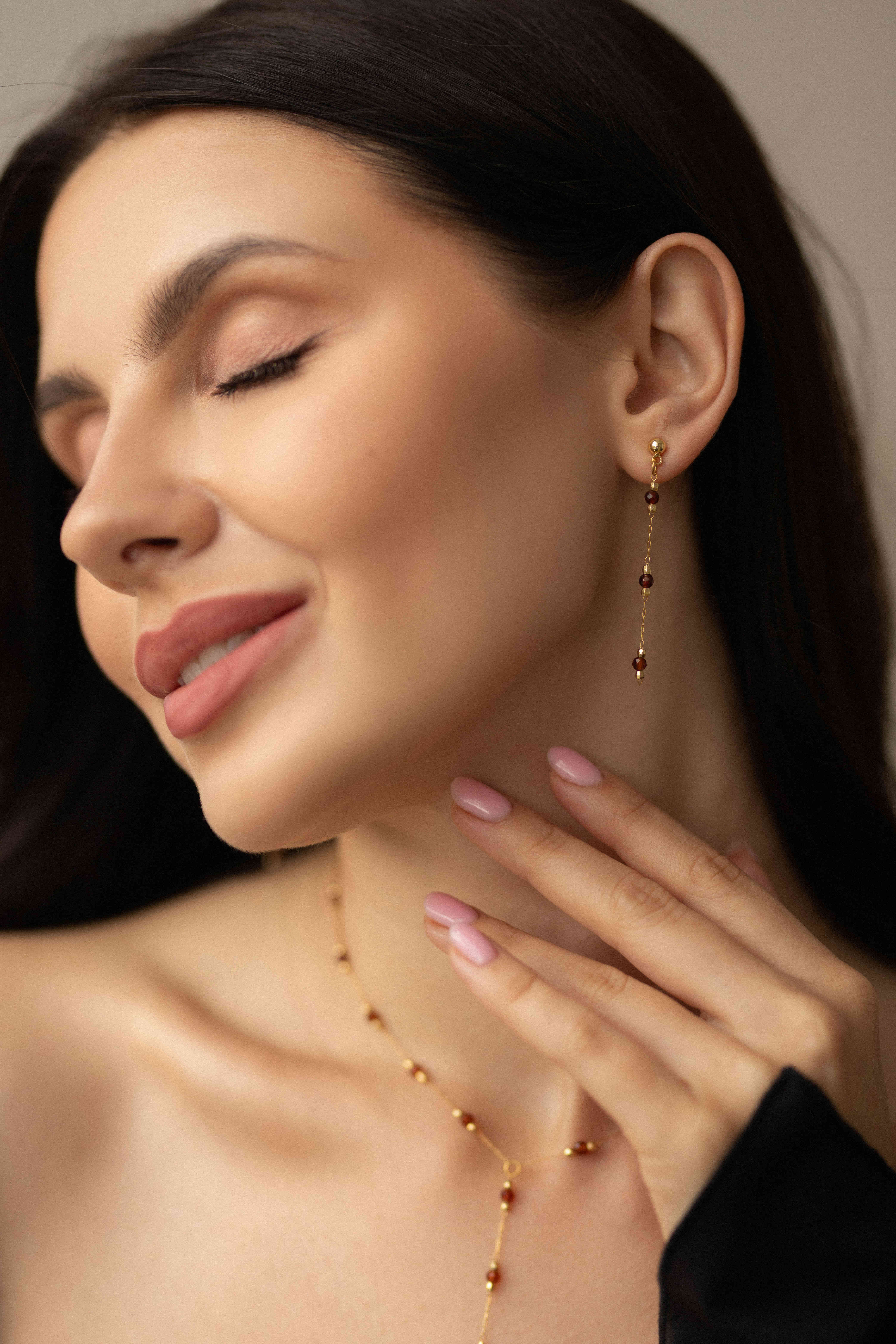 Elevate your look with this elegant jewelry set featuring a lariat necklace with genuine natural garnet stones and matching stud earrings. Crafted from durable brass with luxurious gold plating, this refined duo combines quality and timeless style. The necklace features a graceful tie design, while the dainty garnet stud earrings add a polished finishing touch — perfect for everyday elegance or special occasions.