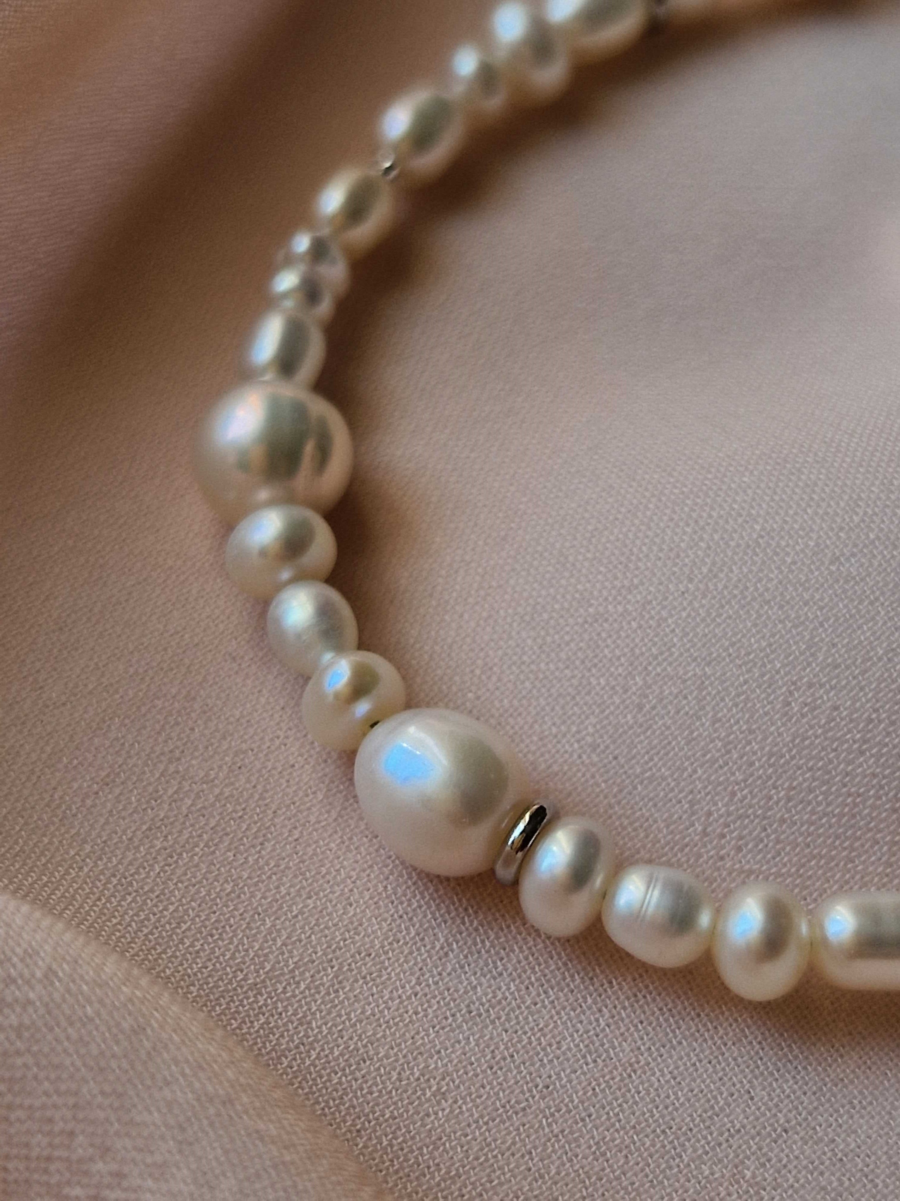 Pearl bracelet on a soft pink fabric background