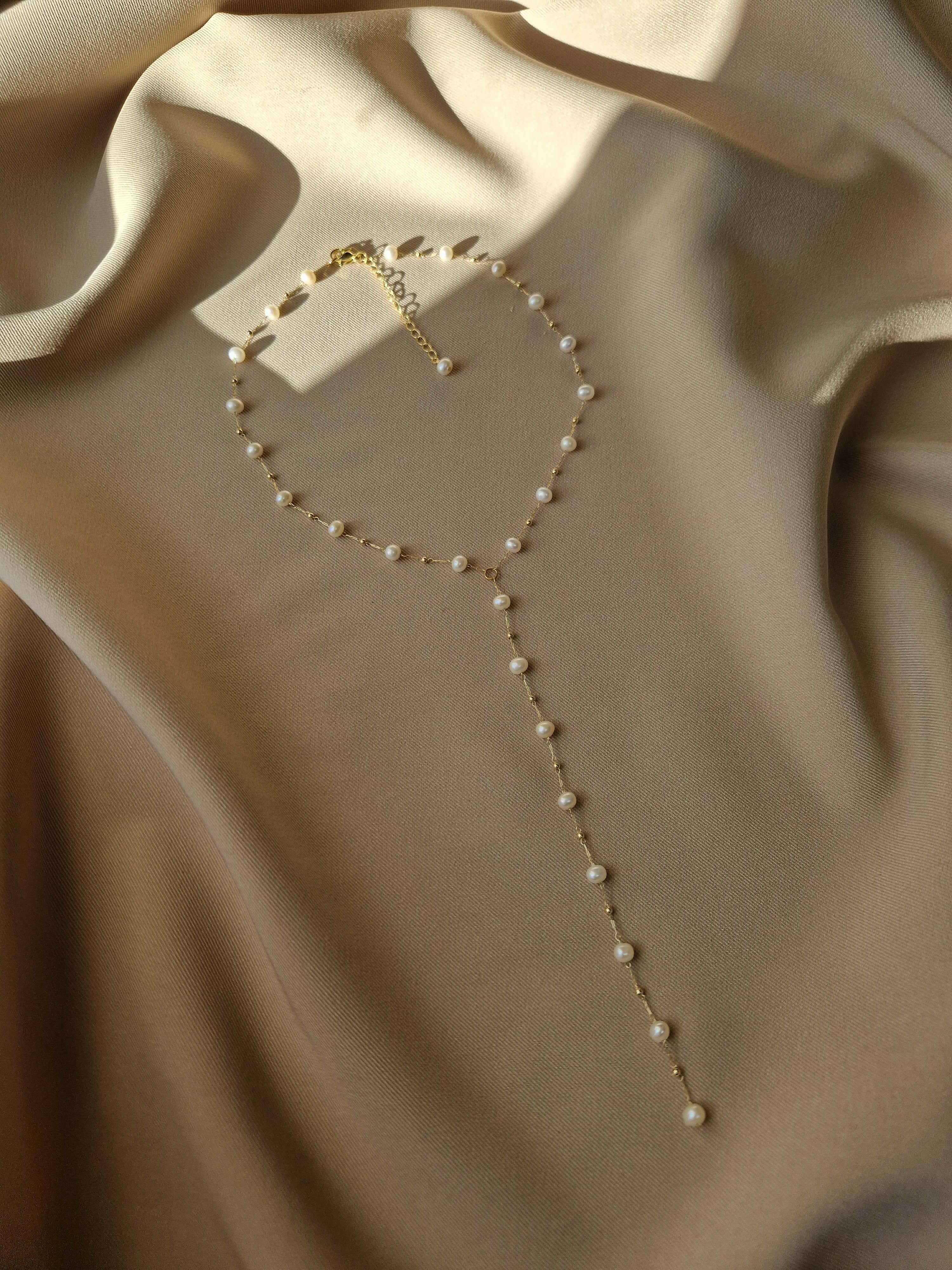 Pearl necklace on a beige fabric background