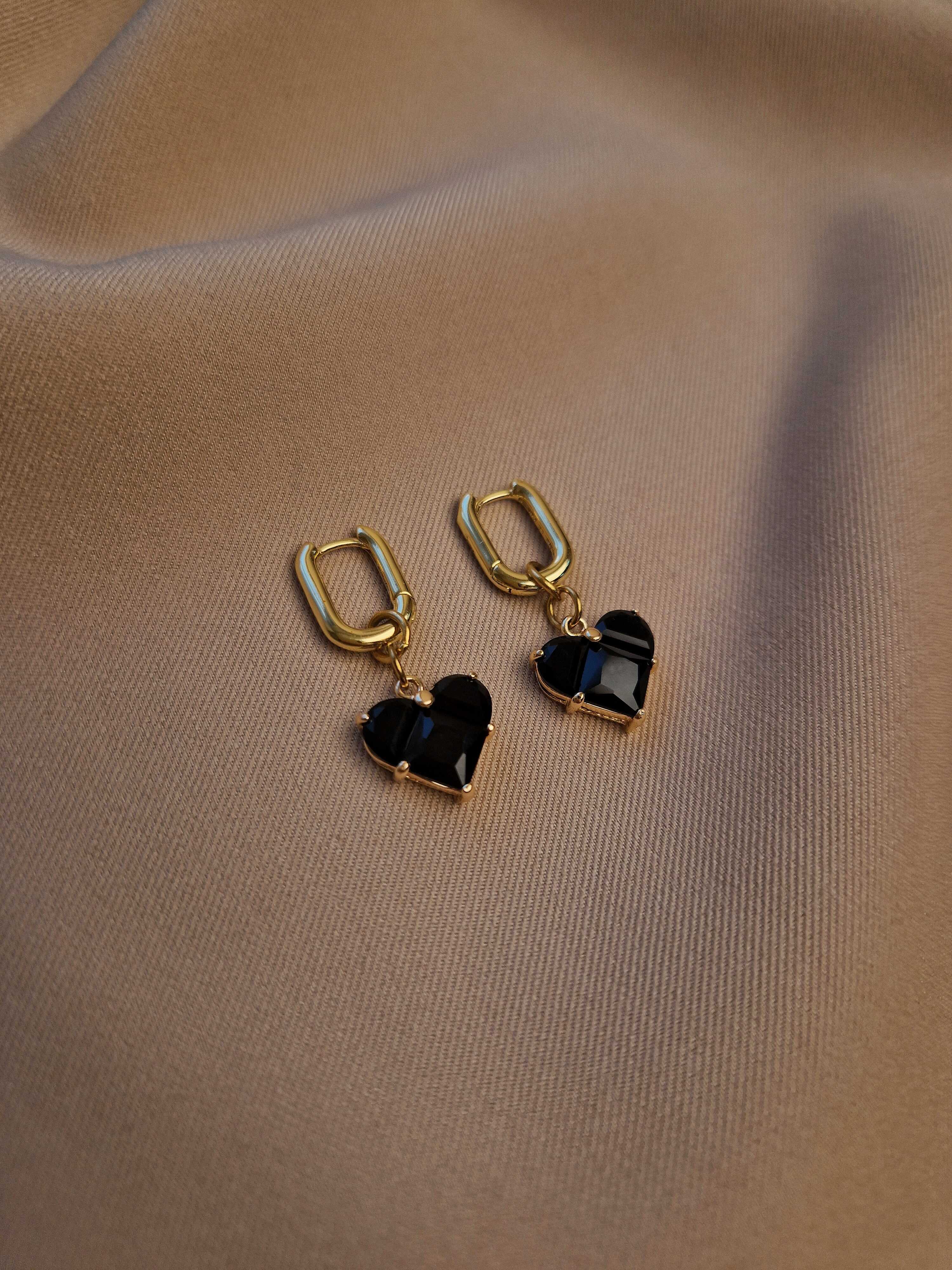 Heart-shaped earrings on a beige fabric background