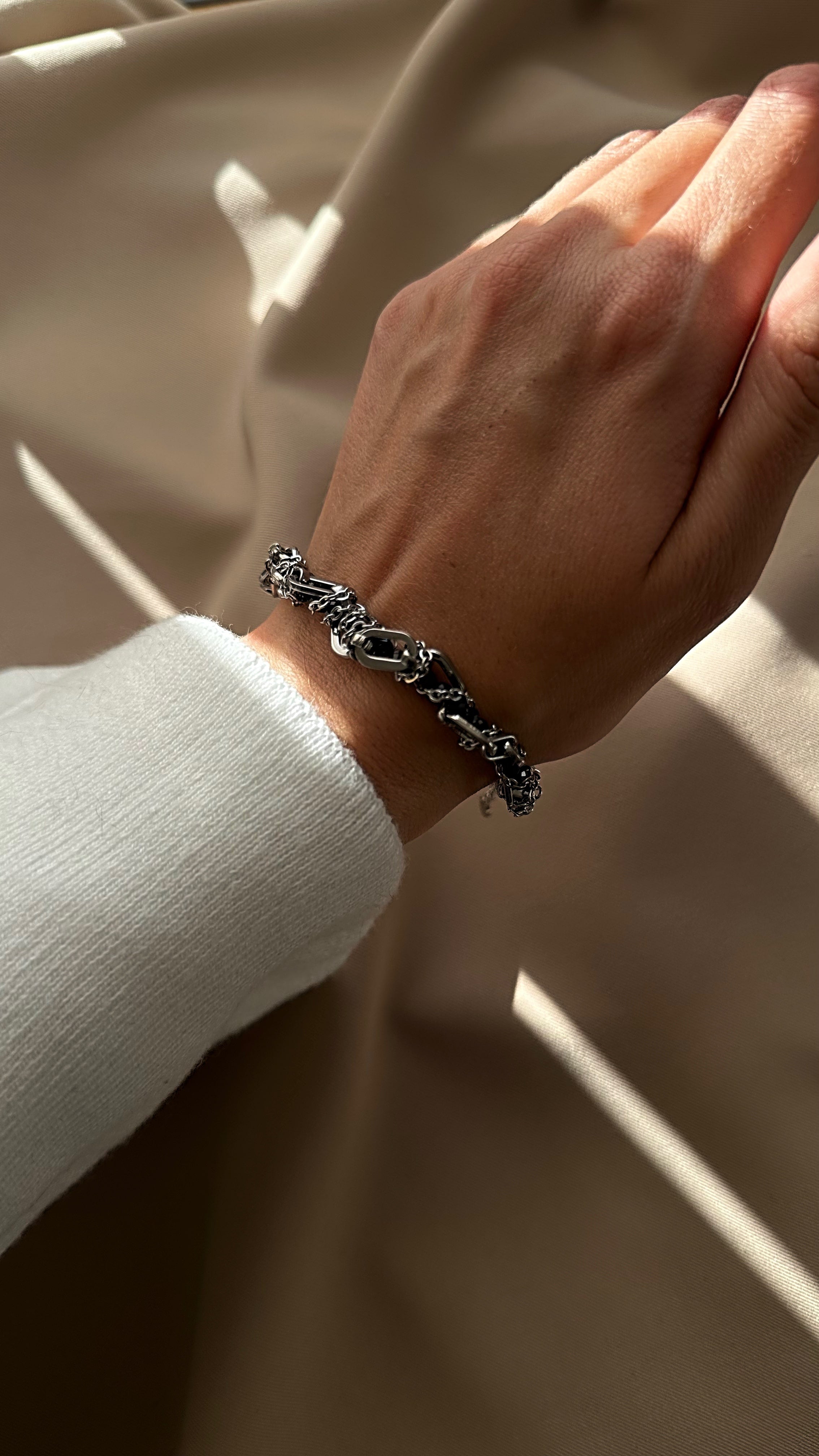 Accent bracelet with natural spinel and silver-tone chains on an adjustable clasp.