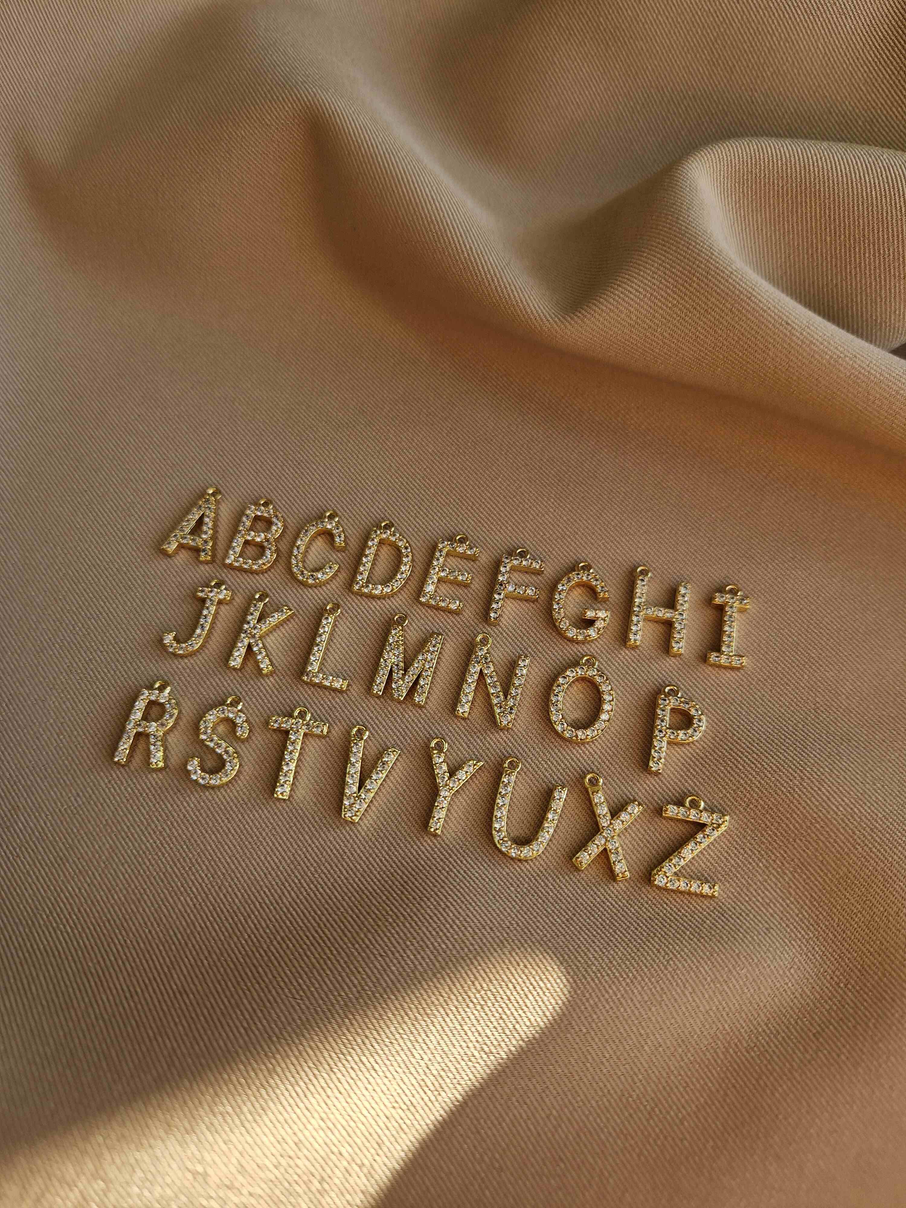 Embroidered alphabet letters on beige fabric