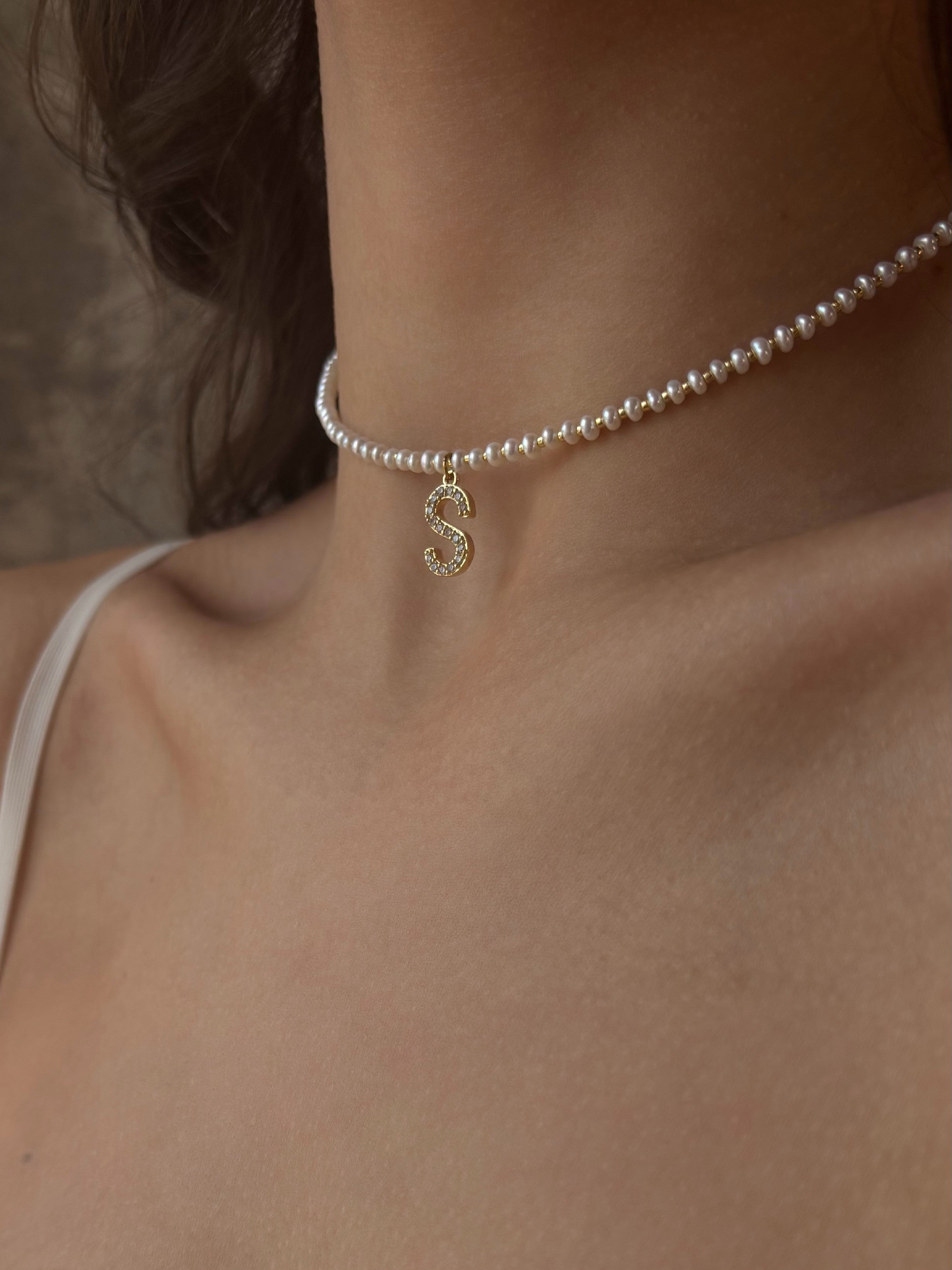 Minimalist choker featuring dainty natural pearls, Japanese galvanic-coated seed beads, and a personalized letter pendant adorned with sparkling cubic zirconia.