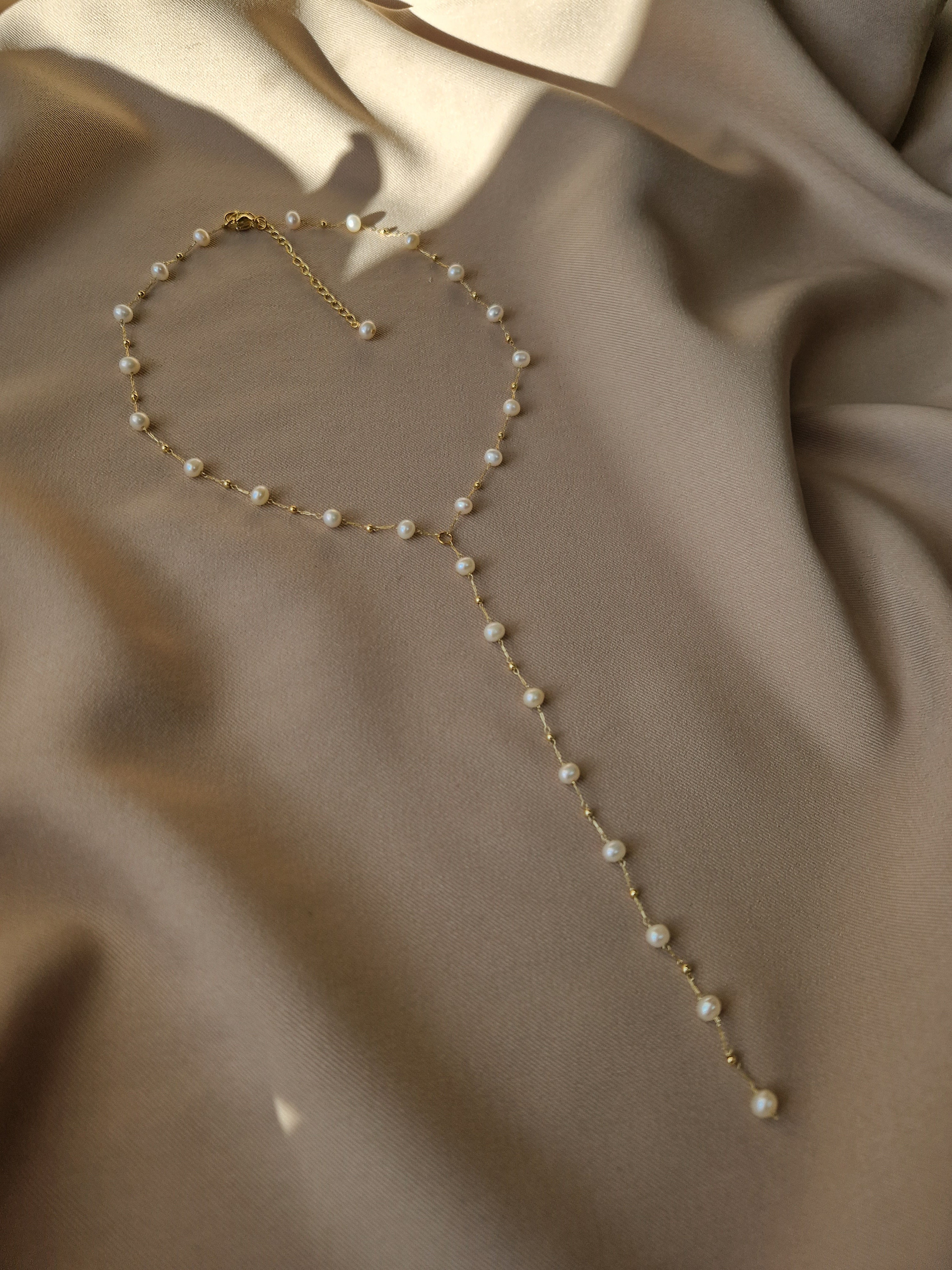 Elegant Y-shaped lariat necklace with natural freshwater pearls on a gold-tone chain, showcasing a delicate and refined design perfect for special occasions and everyday wear.
