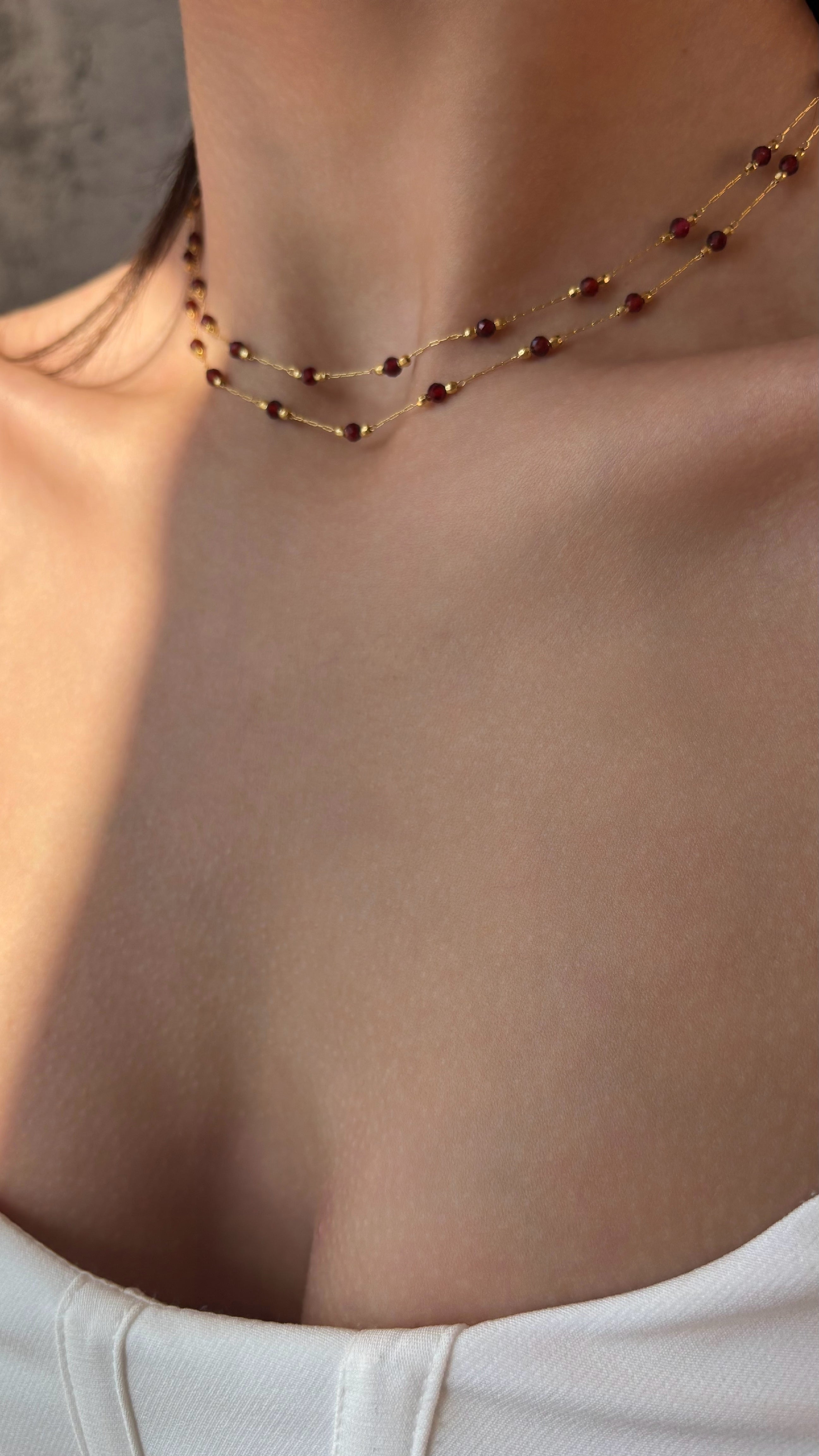 Necklace with red garnet worn by a person