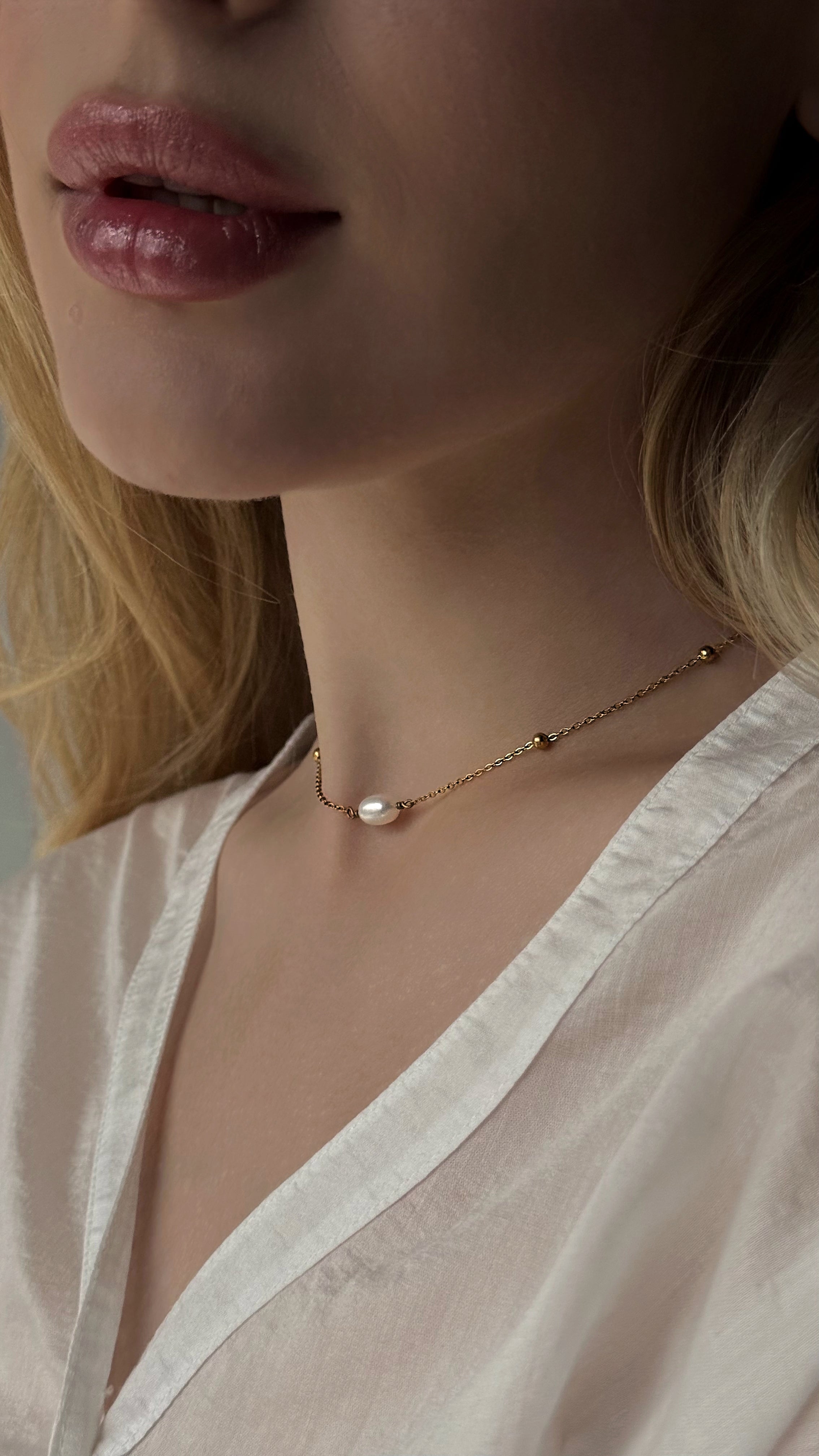 Minimalist gold-tone chain necklace featuring a single natural freshwater pearl. A sleek and elegant design perfect for everyday wear, combining timeless simplicity with modern style. Crafted from durable, hypoallergenic stainless steel for lasting comfort.