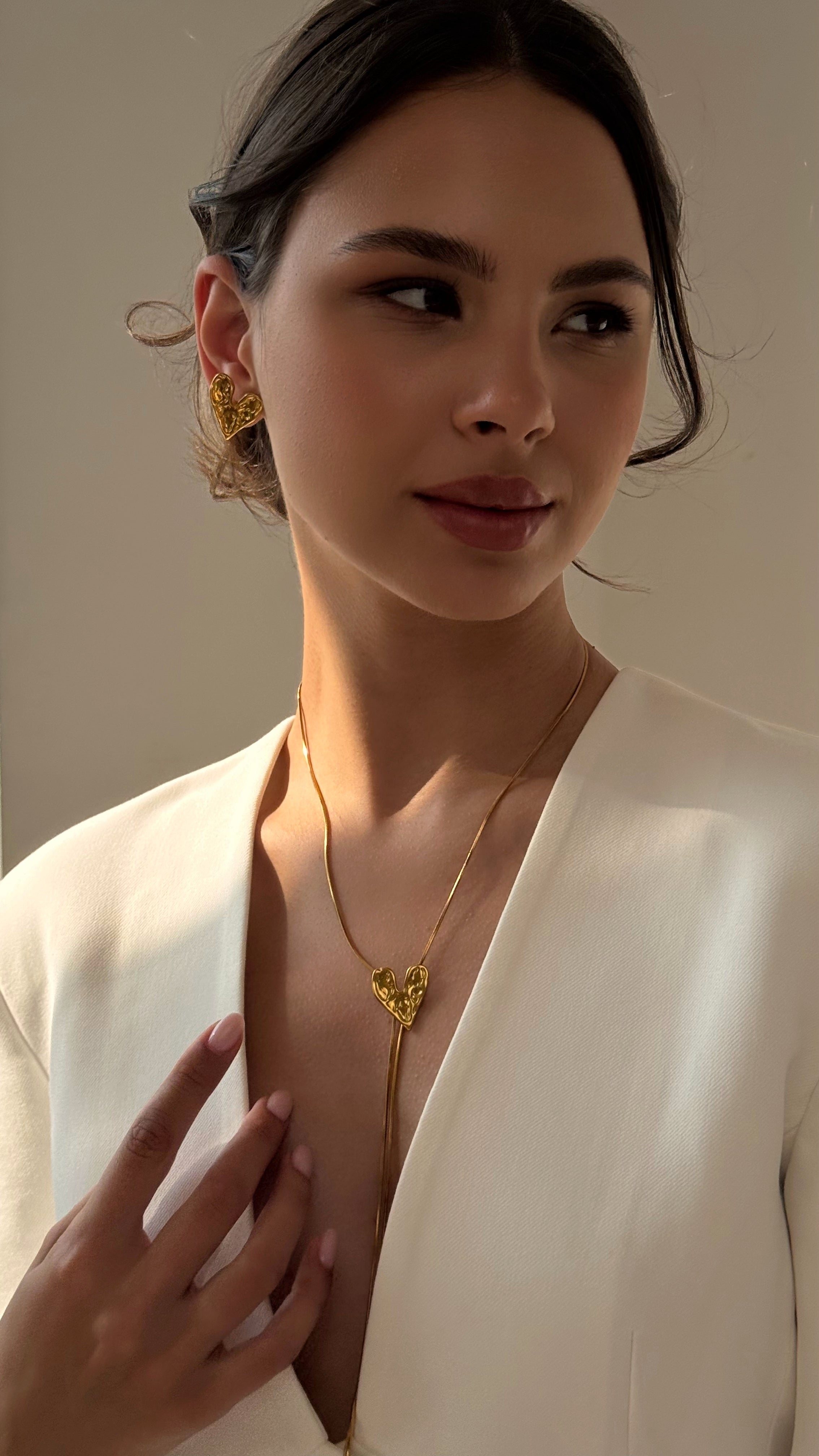 Adjustable lariat necklace with sliding heart pendant, crafted from gold-tone stainless steel — elegant and versatile design offering timeless charm and customizable length, perfect for layering or wearing solo.