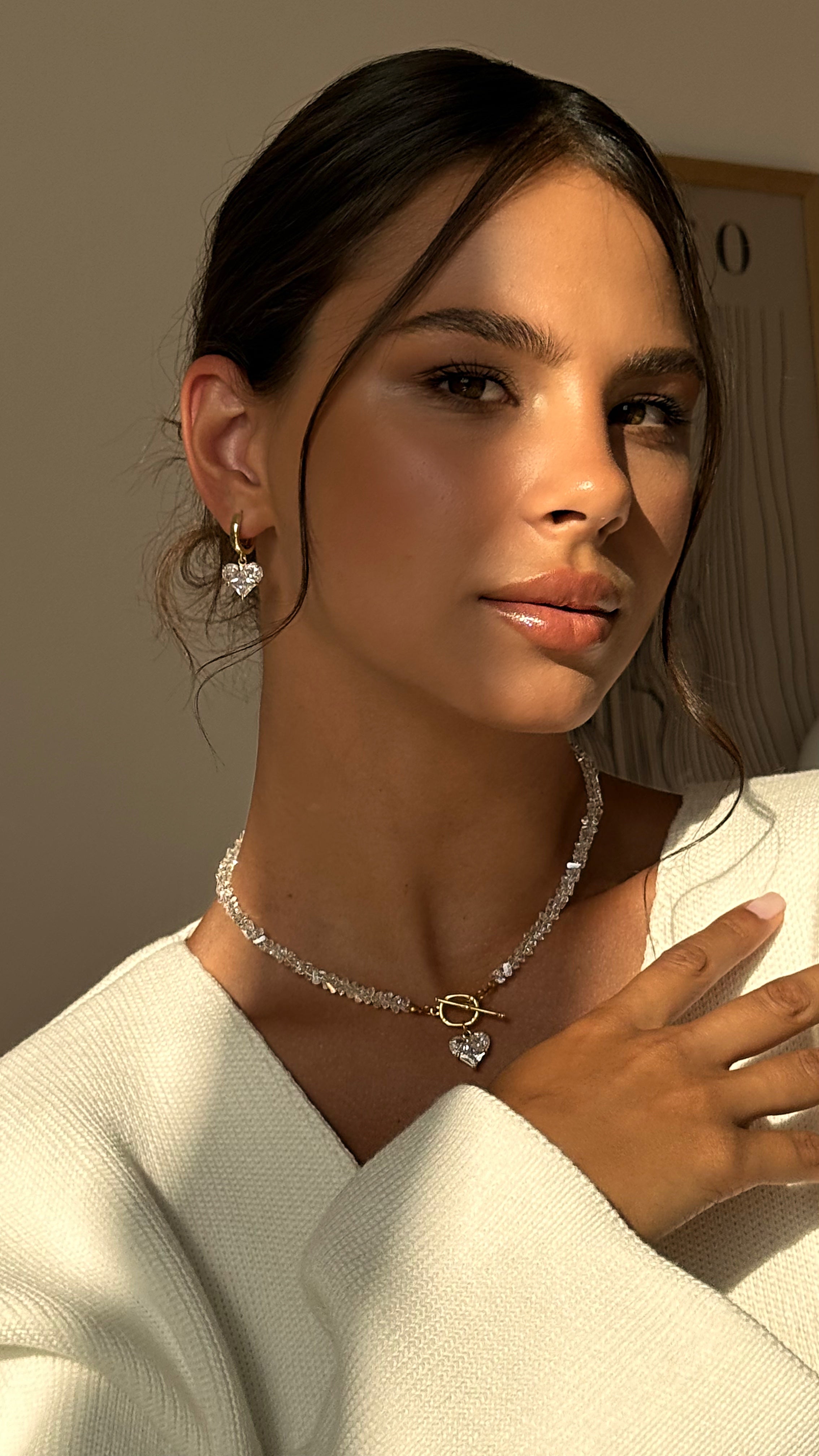 Woman wearing a necklace with a neutral background