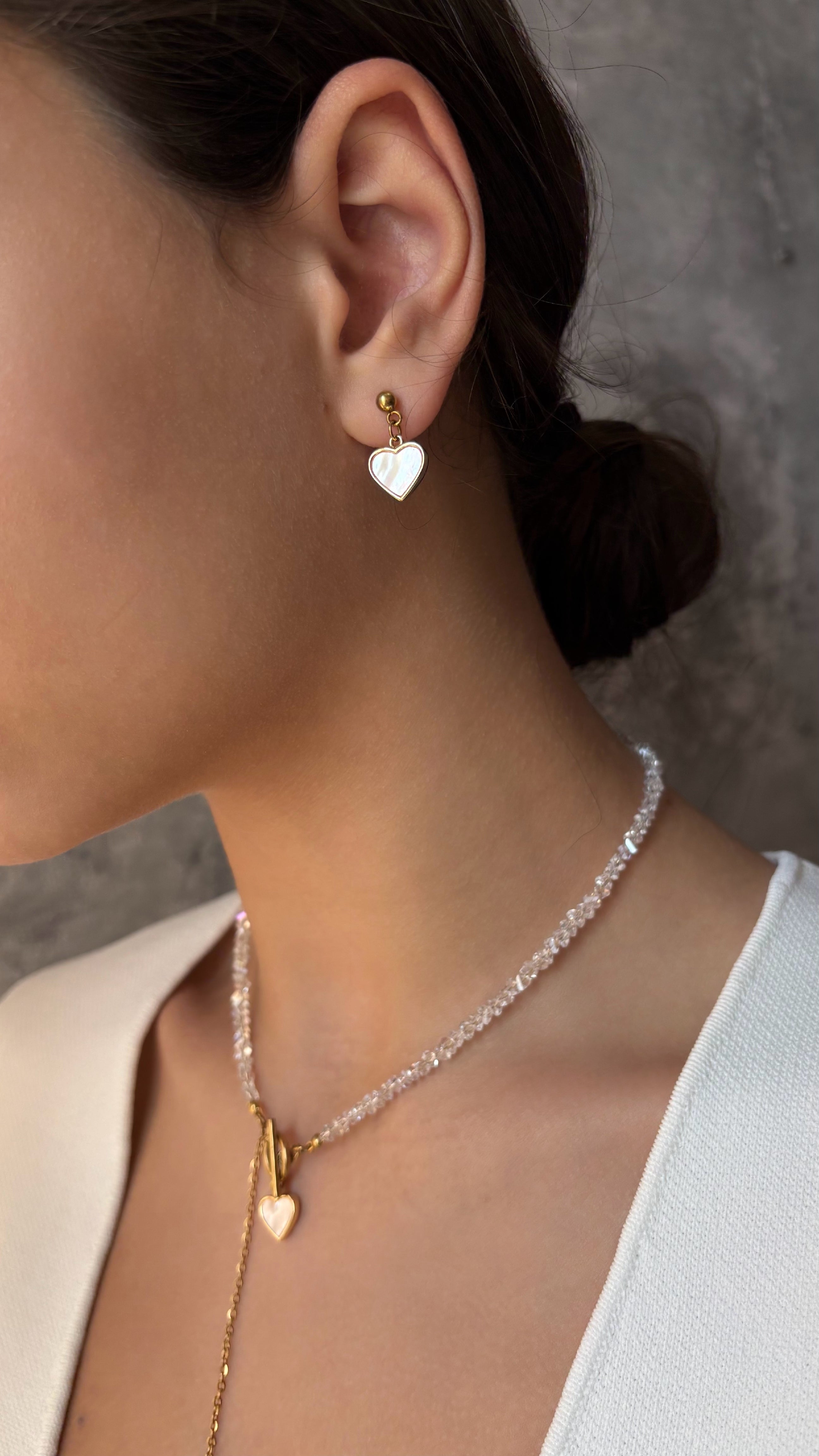 Stud earrings featuring mother-of-pearl heart charms — delicate and elegant design perfect for everyday wear and adding a subtle feminine touch.