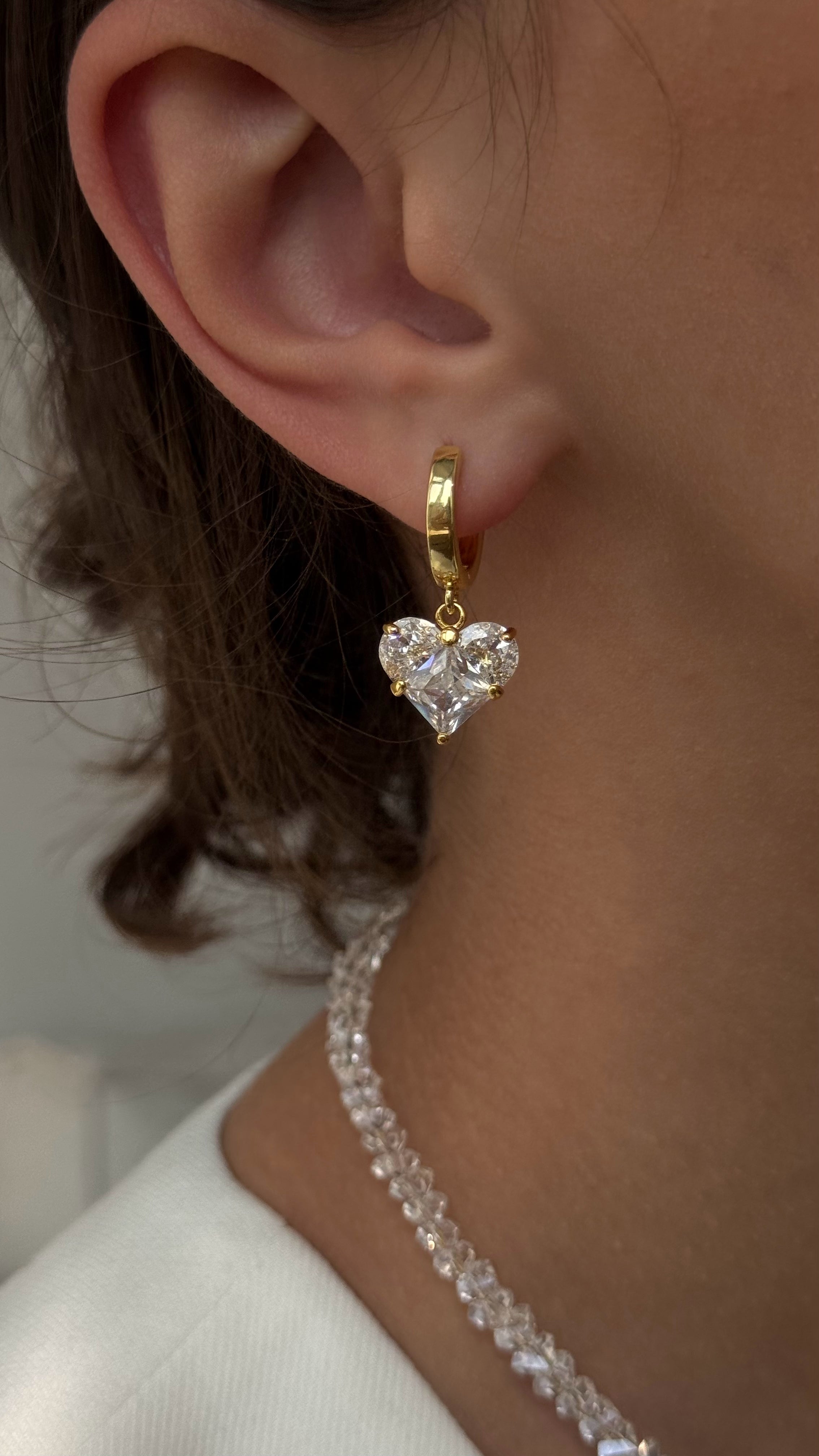 Elegant earrings featuring white heart-shaped accents, combining romantic charm with comfortable design for a graceful everyday look.