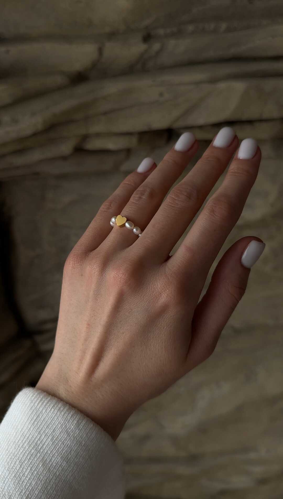 Delicate gold-tone stainless steel ring adorned with natural freshwater pearls and a heart-shaped bead, blending timeless elegance with a meaningful design.