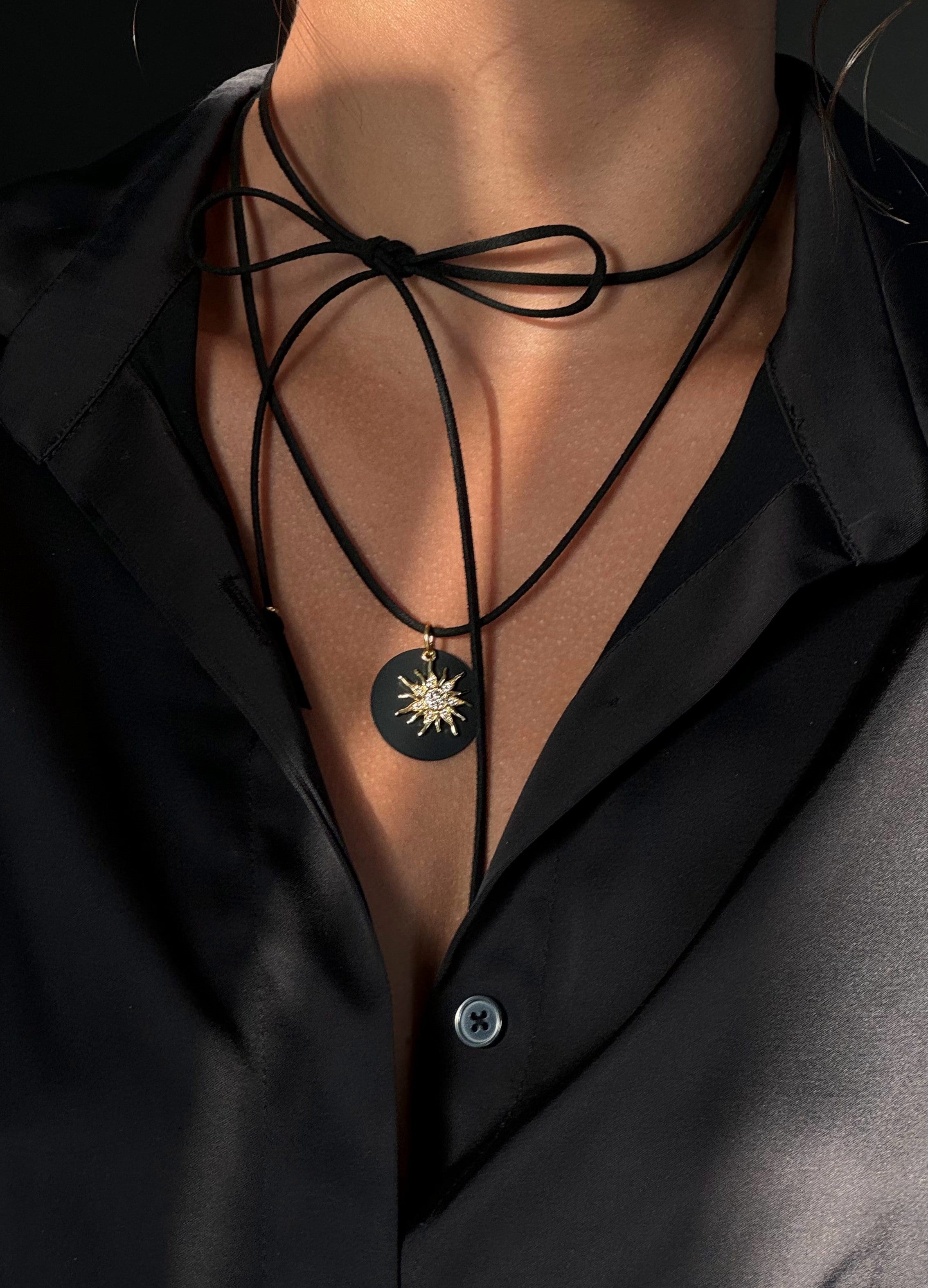 Bold black eco-suede cord necklace with removable cubic zirconia pendant, 150 cm versatile length, plus delicate sun-shaped earrings — stylish set for everyday and special occasions.