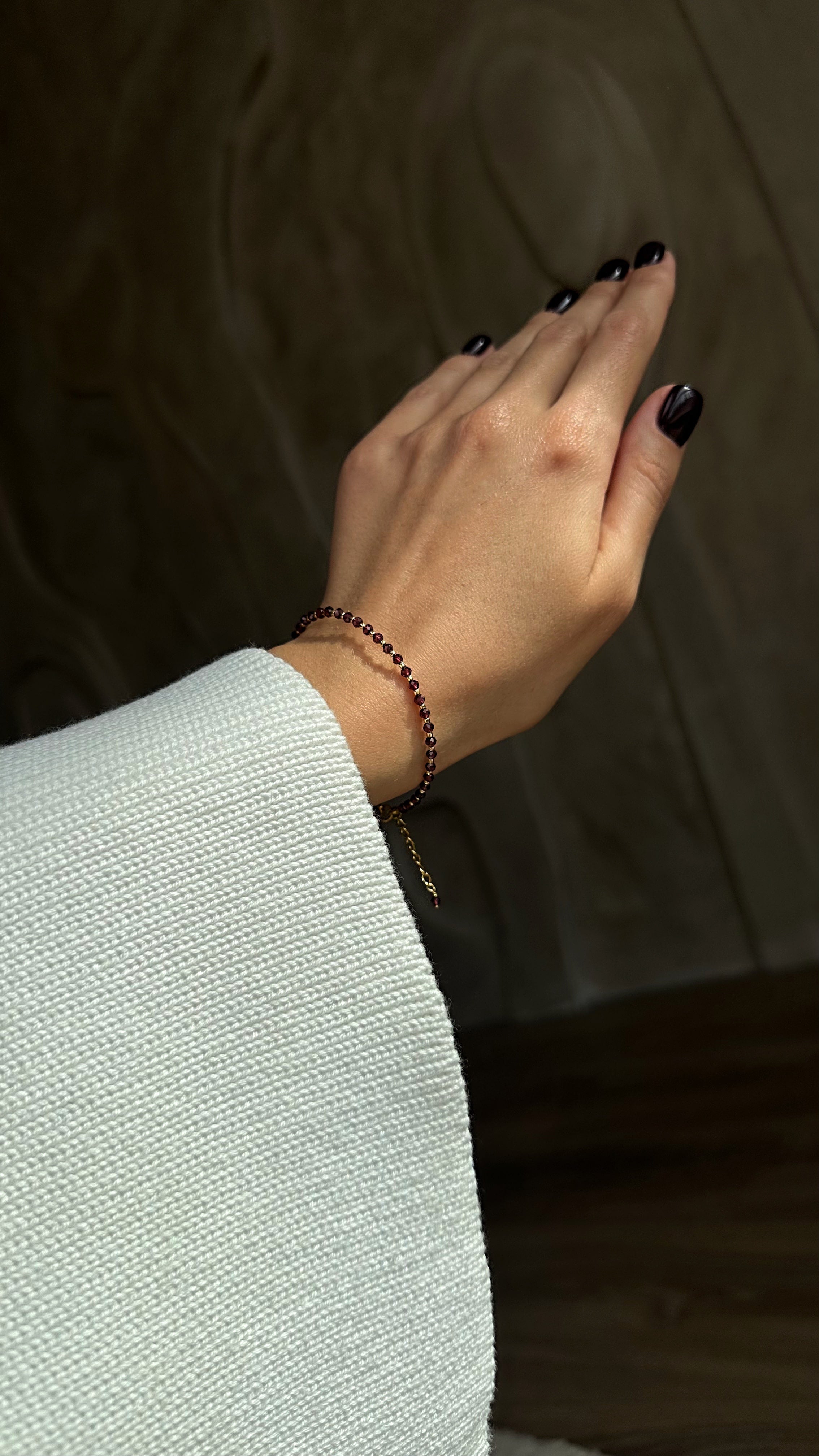 Hand wearing a bracelet with a blurred background