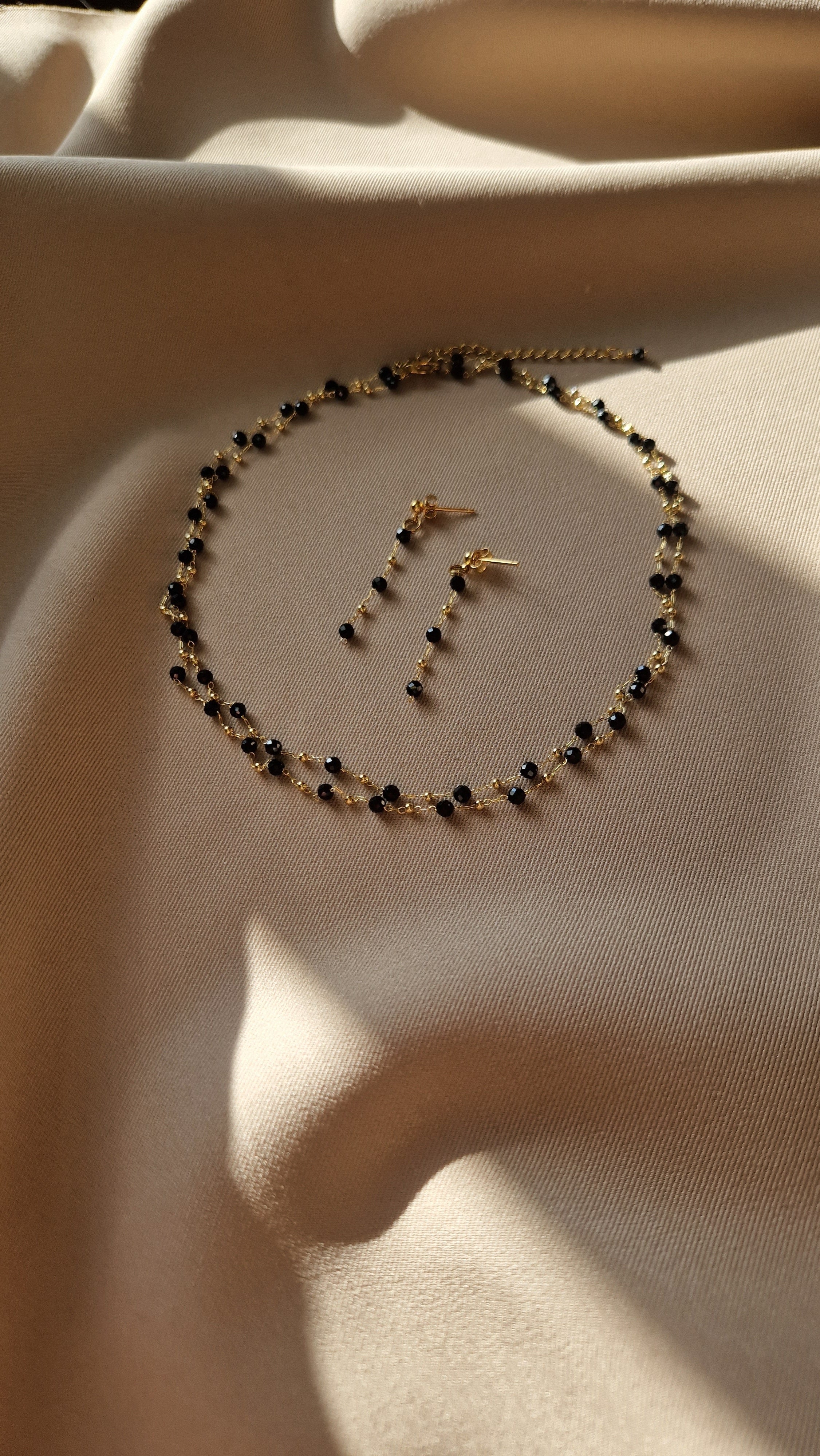 Double-layered gold-plated brass necklace with natural spinel accents and matching long stud earrings featuring genuine spinel stones, radiating warmth and sophistication.
