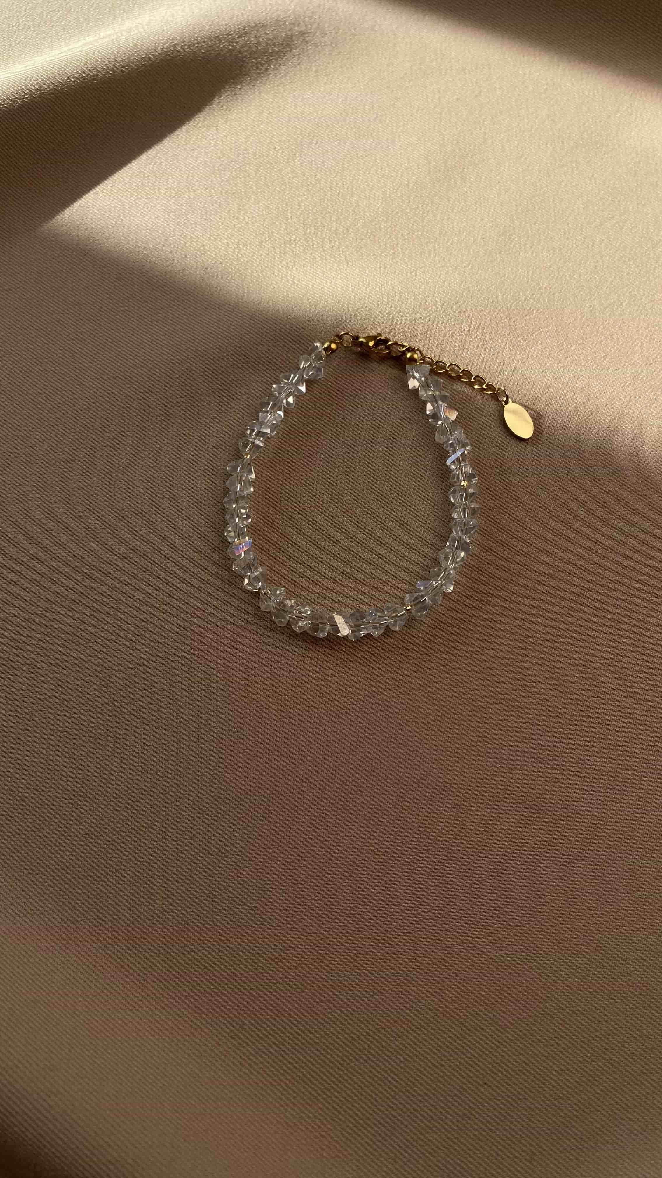 Bracelet with clear beads of crystal on a beige fabric background