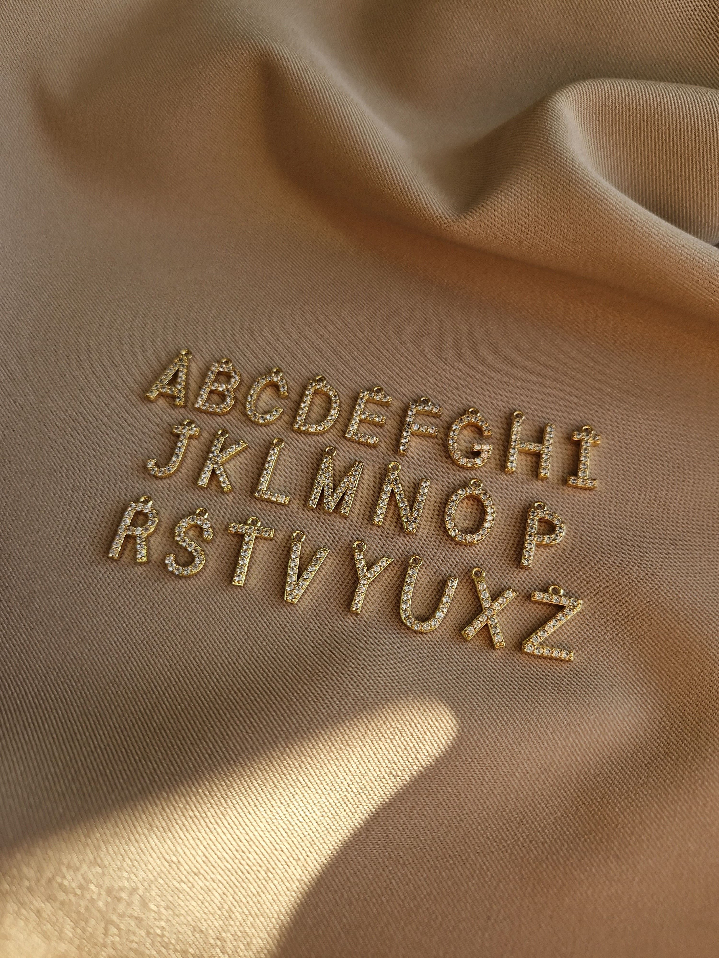 Embroidered alphabet letters on beige fabric