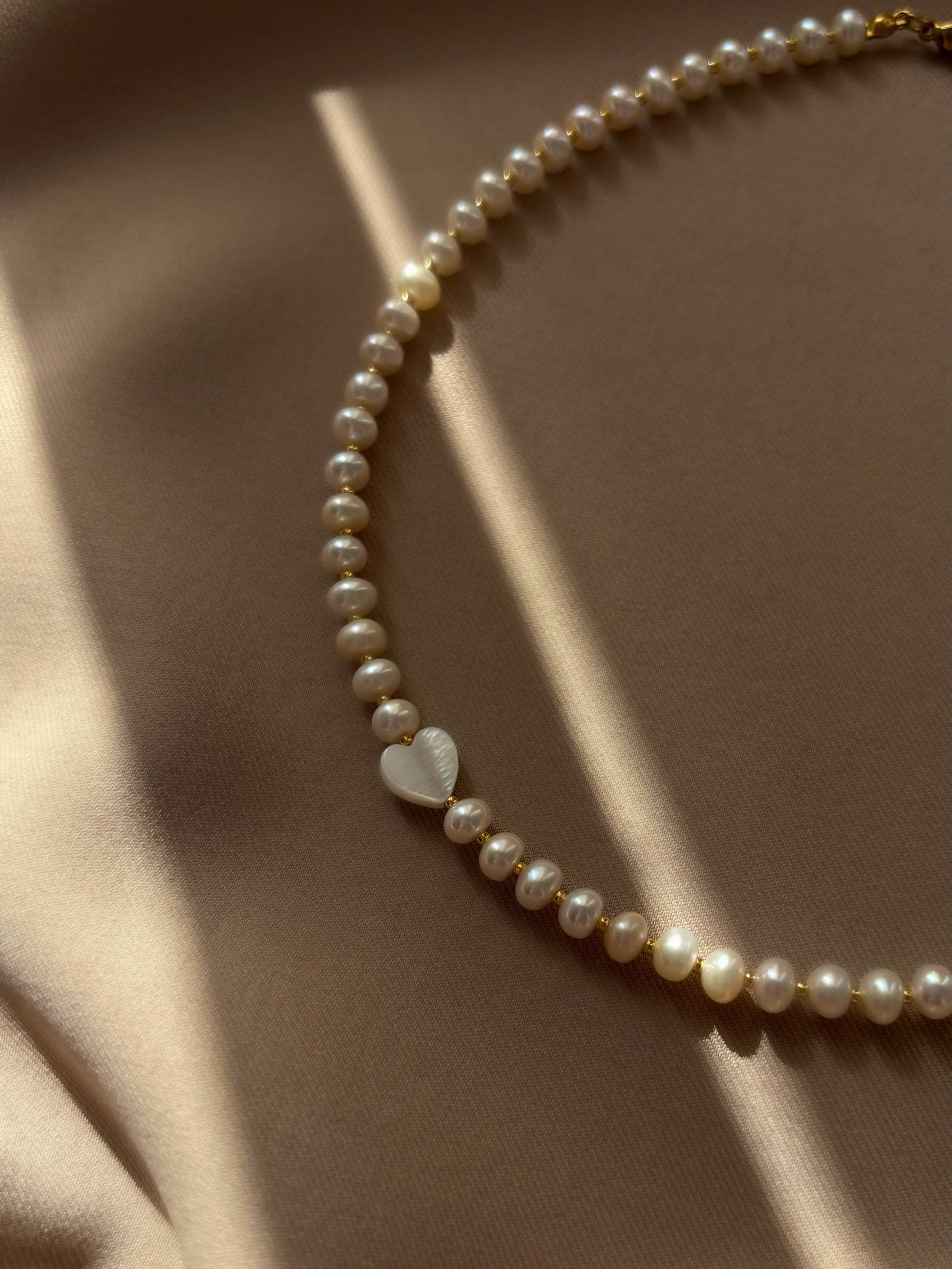 Delicate natural pearl choker featuring a unique mother-of-pearl heart pendant — soft, feminine, and timeless design that highlights grace and elegance for any occasion.