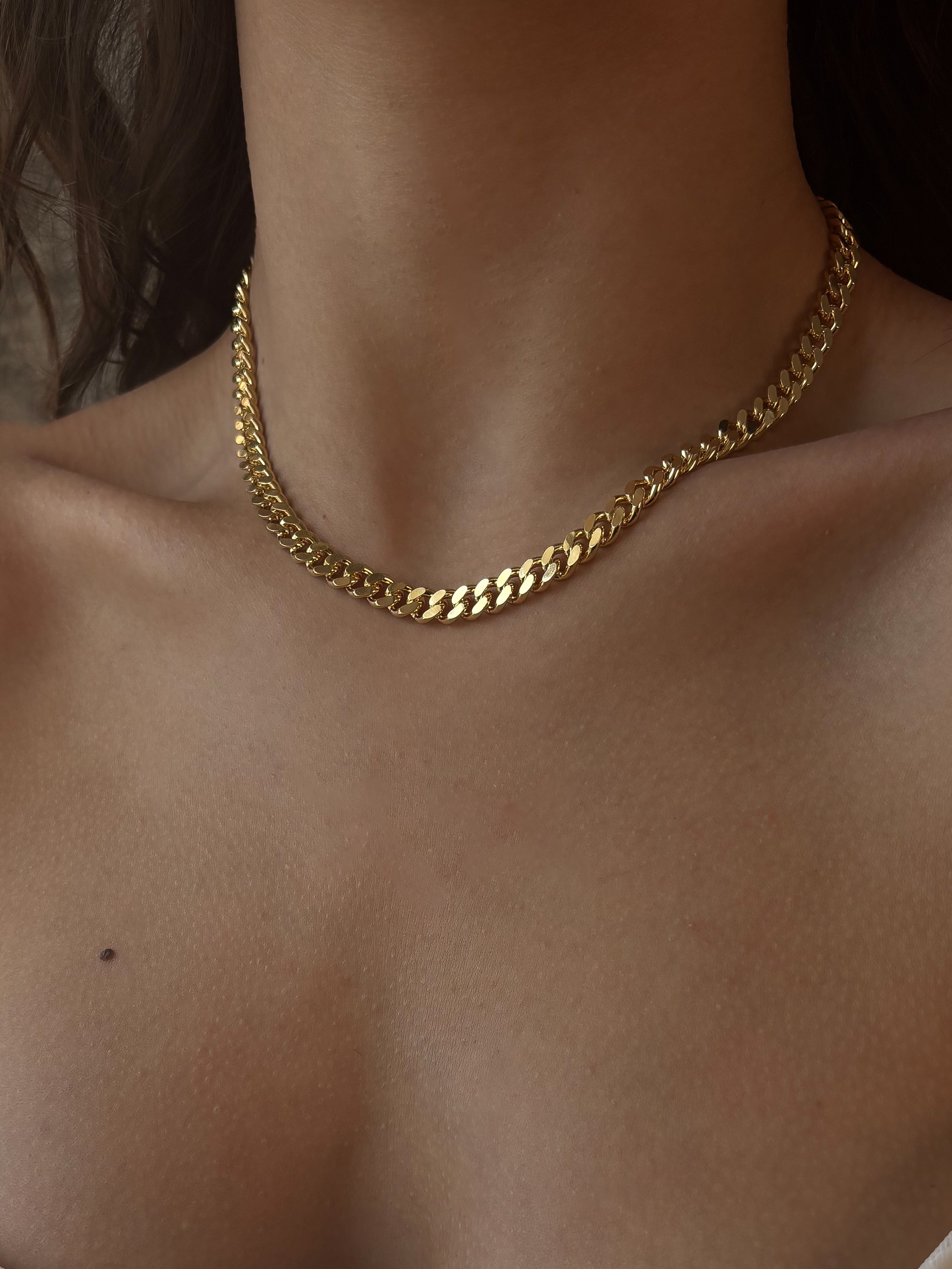 Gold-plated chain necklace on a person's neck