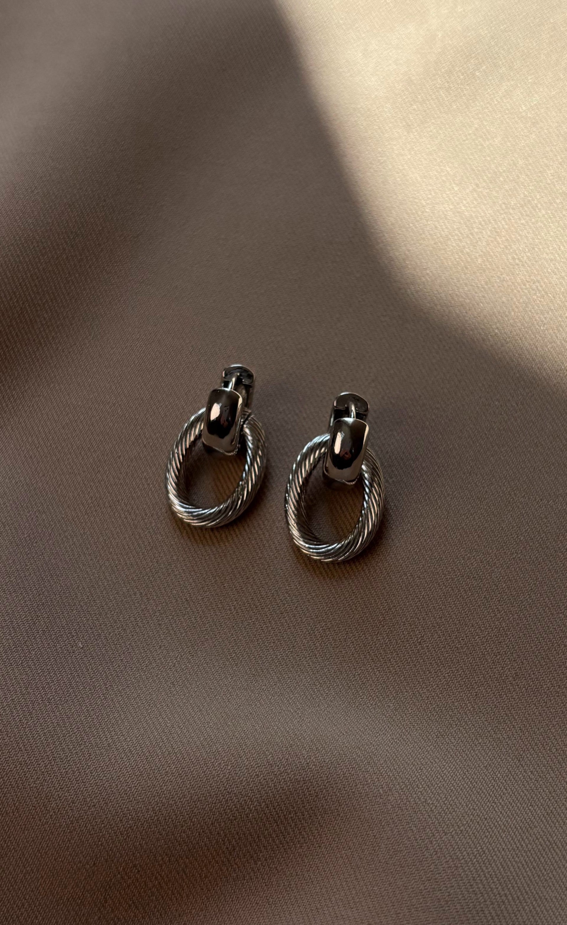 Versatile silver-tone earrings with detachable links, allowing for two styles — minimalist studs or bold statement earrings, designed for comfort and easy pairing with a matching chain necklace.