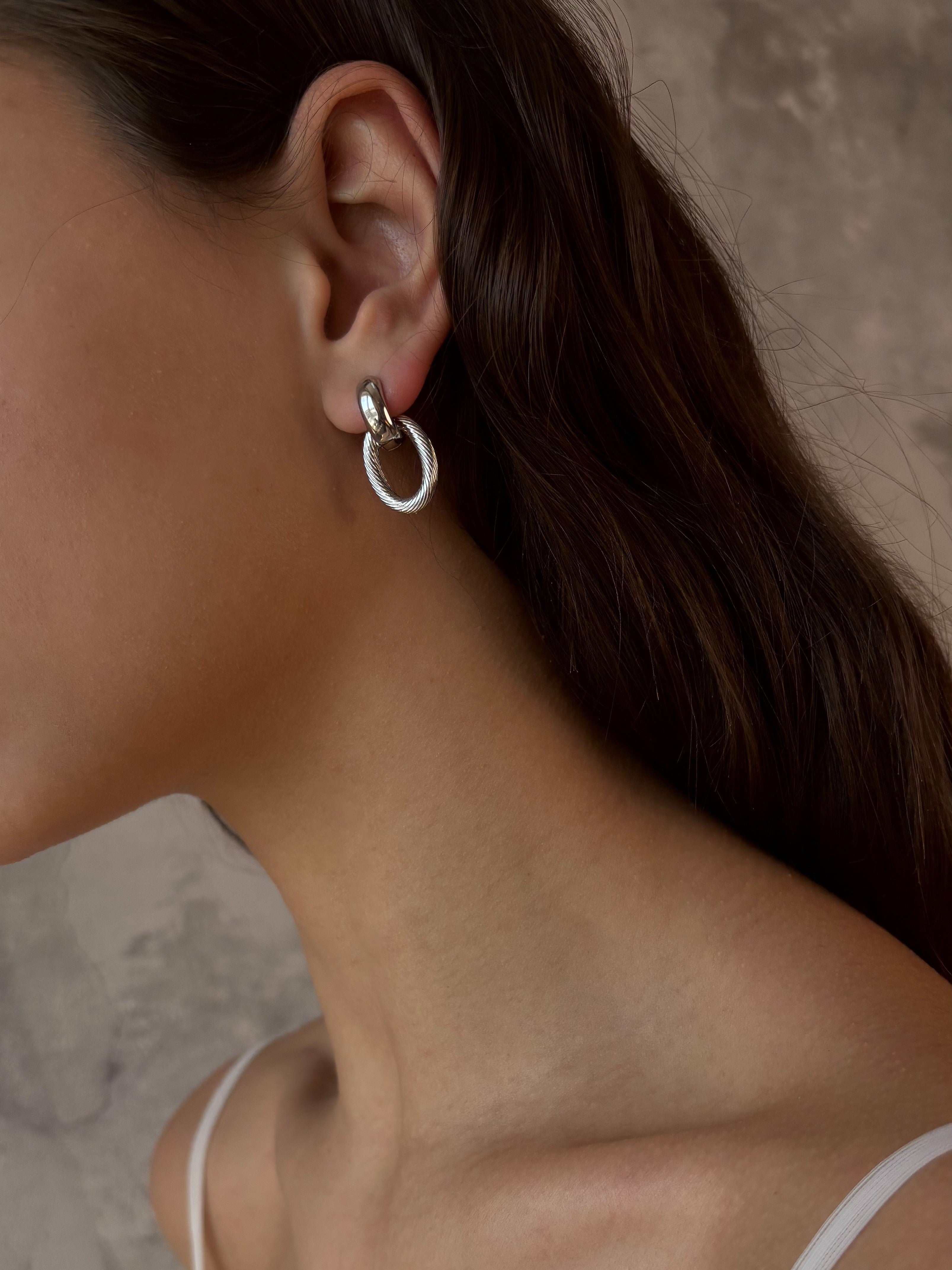 Versatile silver-tone earrings with detachable links, allowing for two styles — minimalist studs or bold statement earrings, designed for comfort and easy pairing with a matching chain necklace.