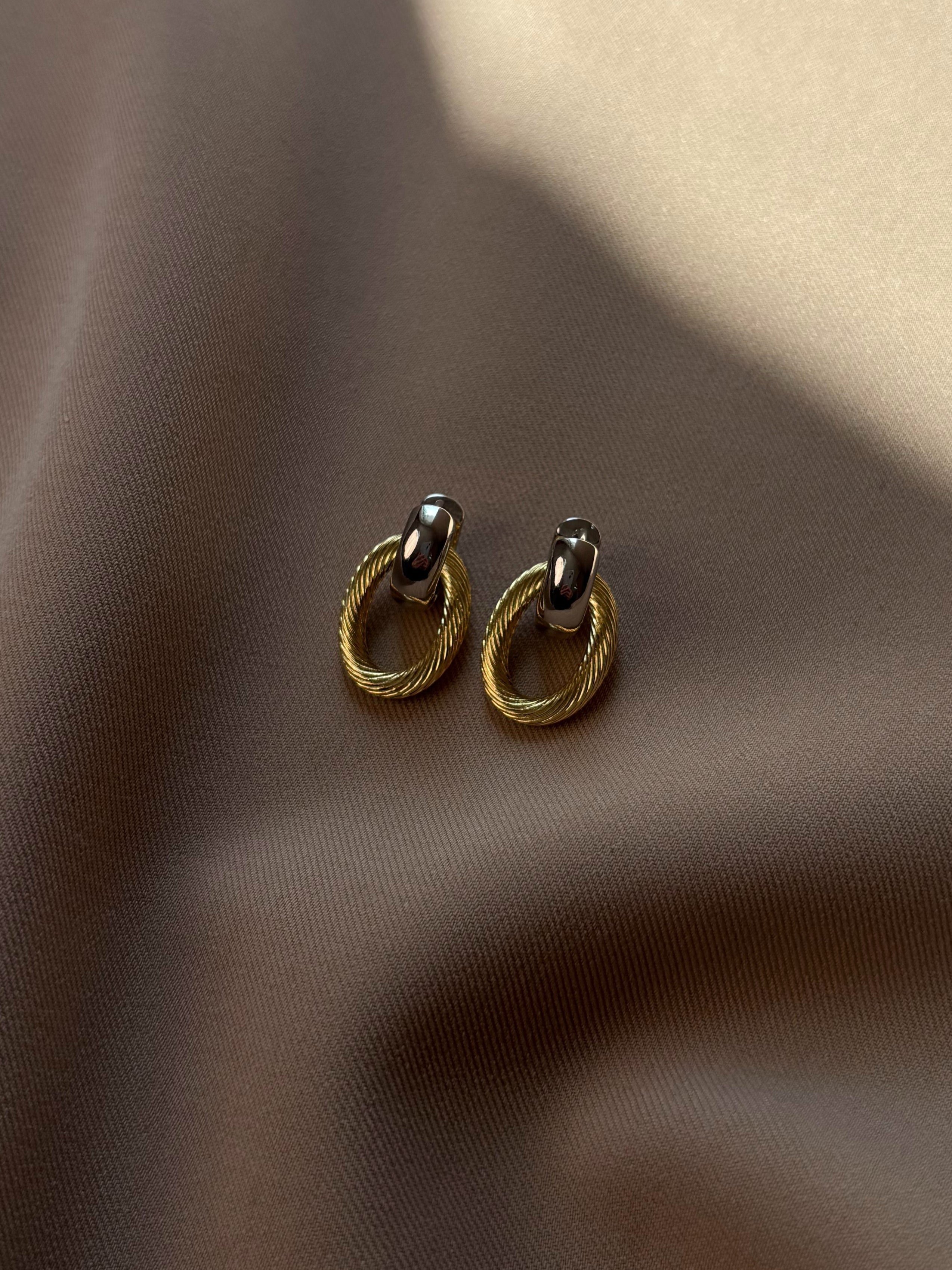 Bi-color earrings with detachable gold-tone links, offering versatile wear as silver-tone studs or bold mixed-metal statement earrings, designed for comfort and easy style transitions.