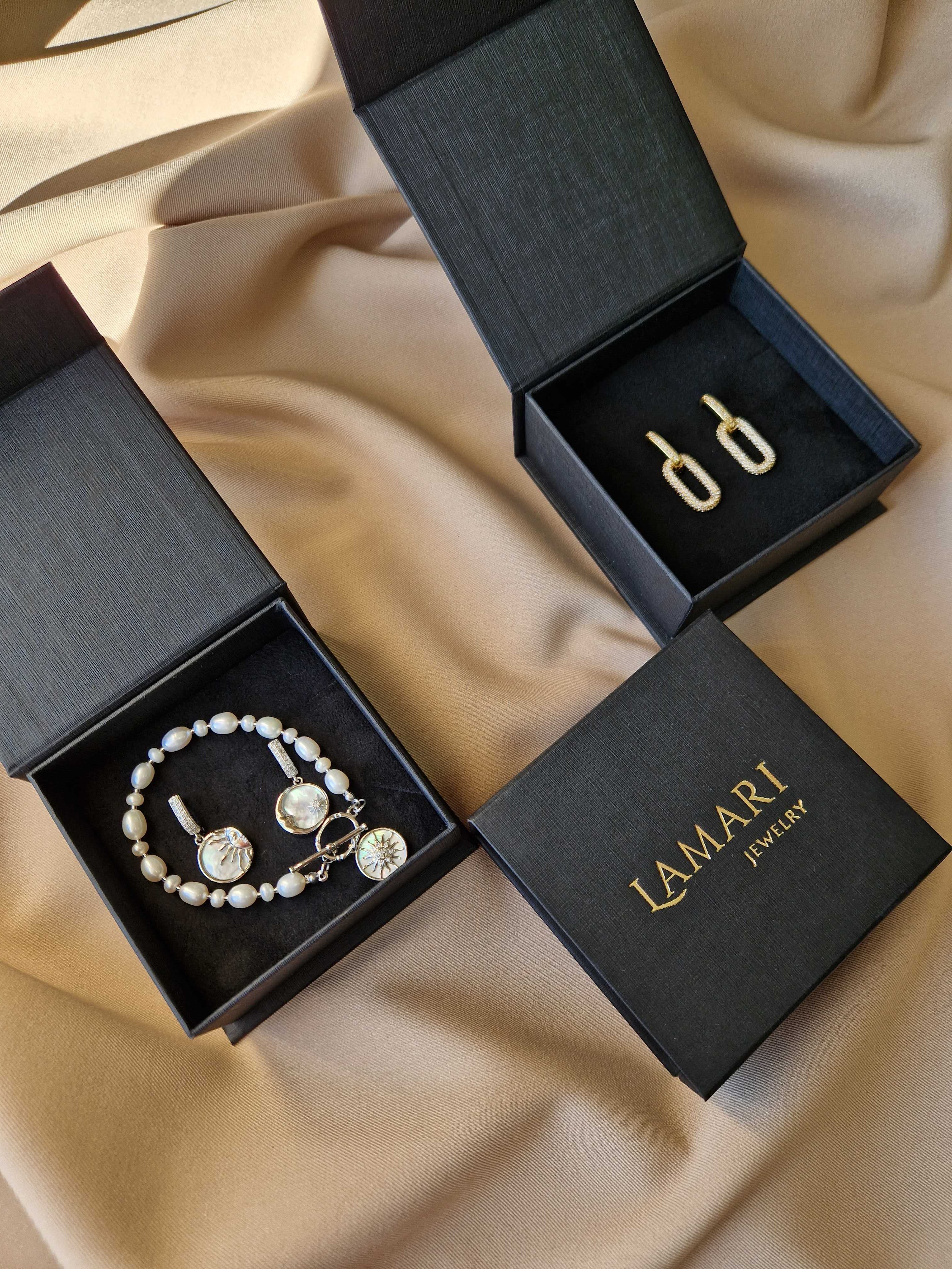 Black gift box with embossed gold-colored brand logo — elegant and stylish packaging for jewelry.