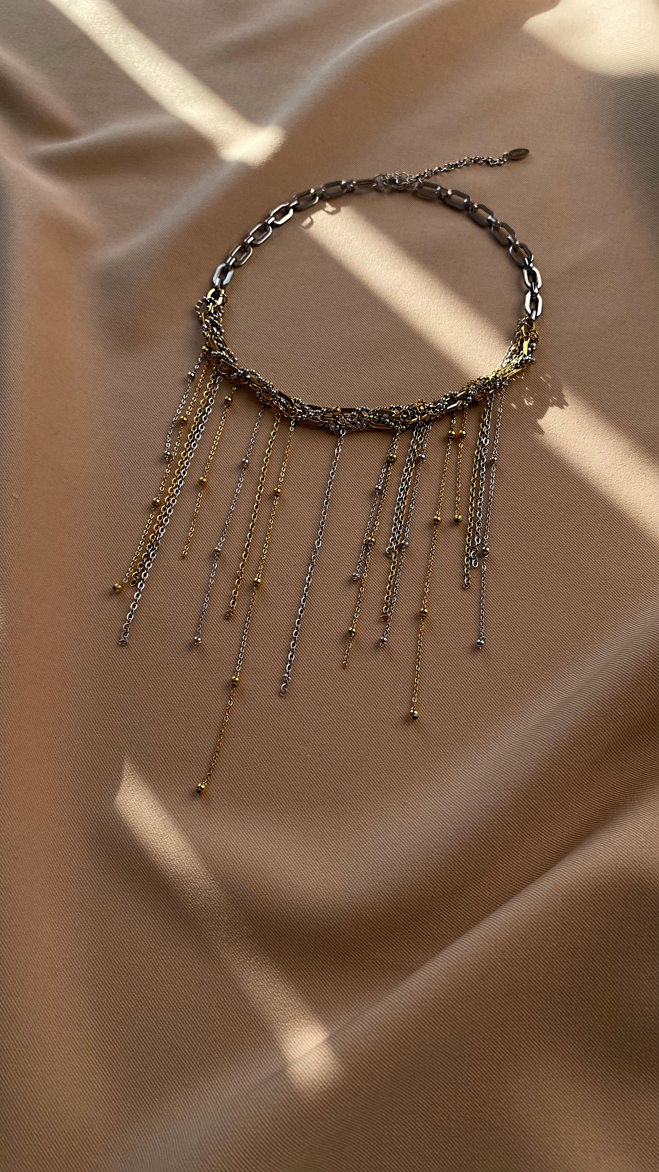 Bold bi-color statement necklace combining gold and silver-tone chains of different sizes and textures. Made from jewelry-grade stainless steel. 