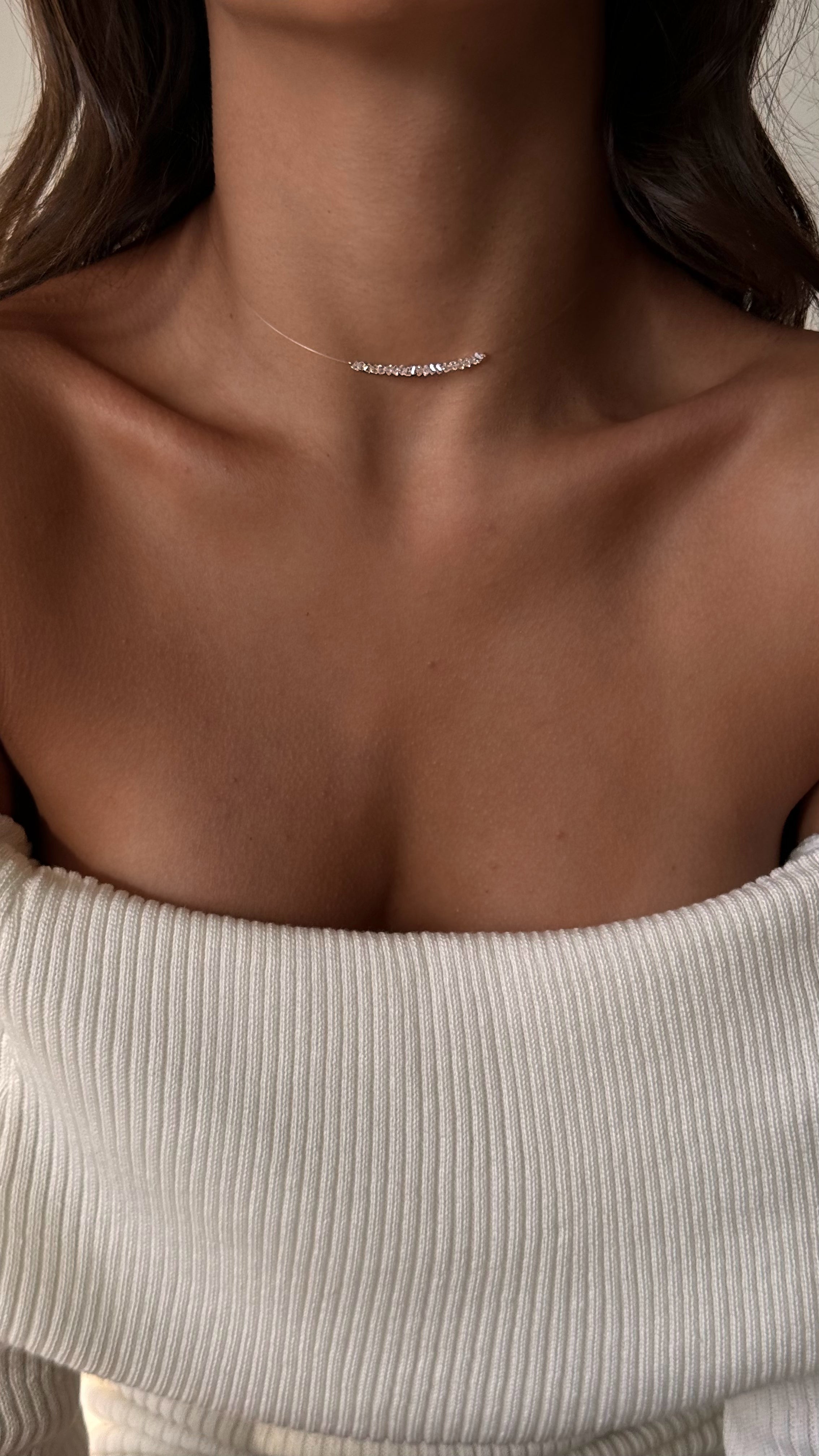 Delicate minimalist choker with transparent faceted crystal beads strung on clear flexible jewelry wire, offering a weightless and elegant look with lasting comfort.