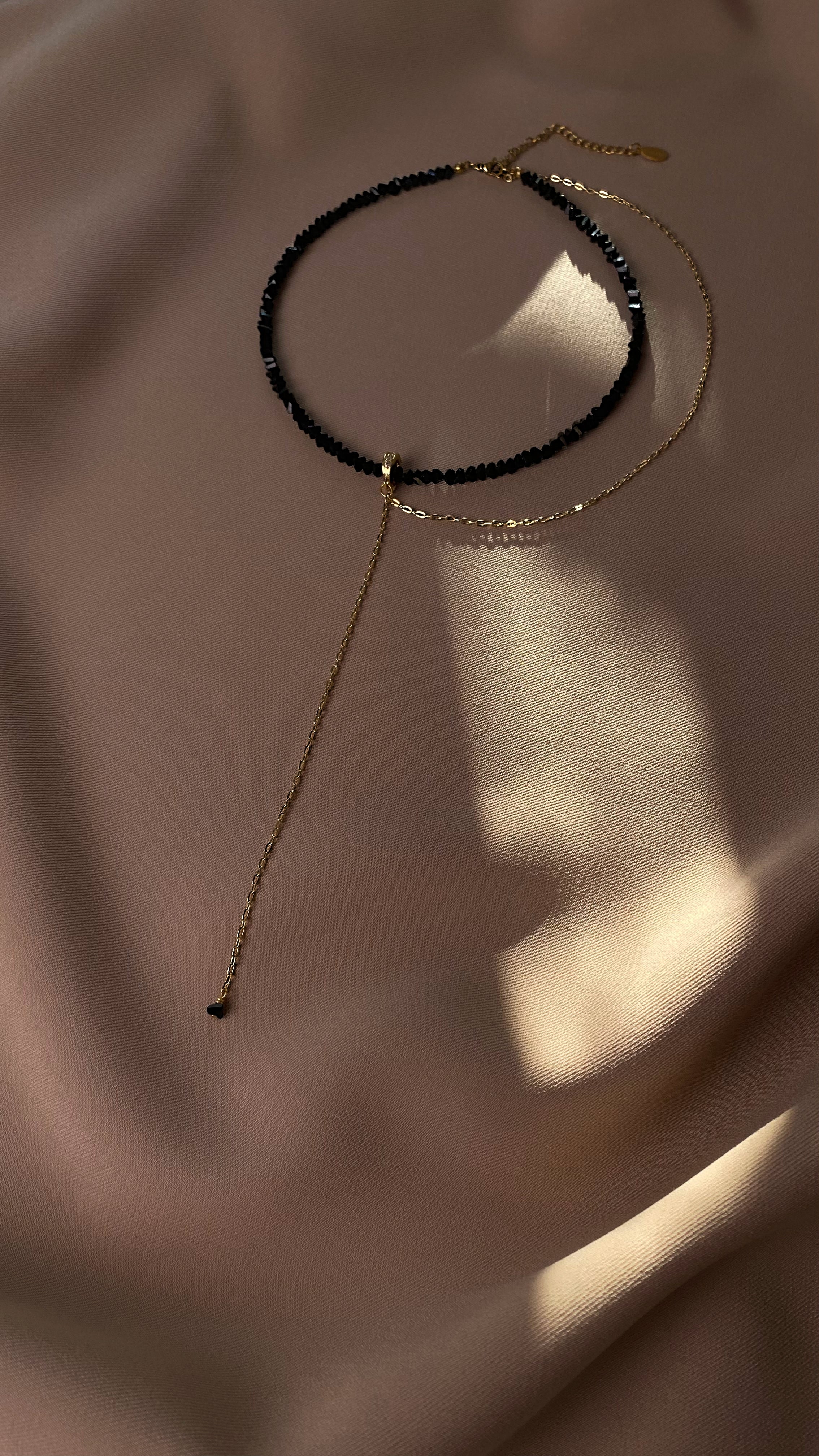 Two necklaces on a soft fabric background
