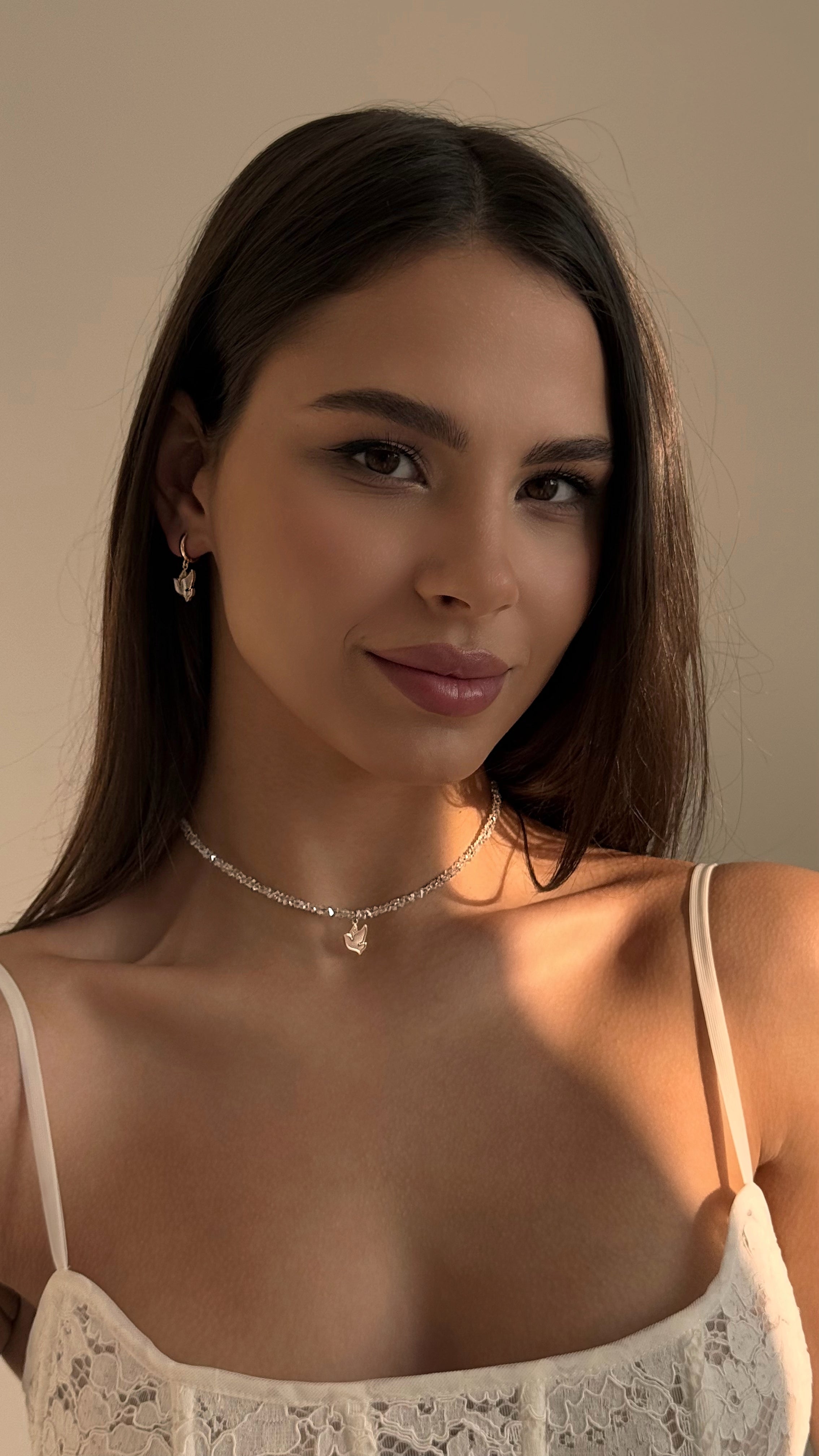 Delicate jewelry set featuring a transparent crystal choker with mother-of-pearl bird pendant and matching earrings with natural mother-of-pearl — elegant and feminine design with gold-plated stainless steel for durability and timeless everyday or special occasion wear.