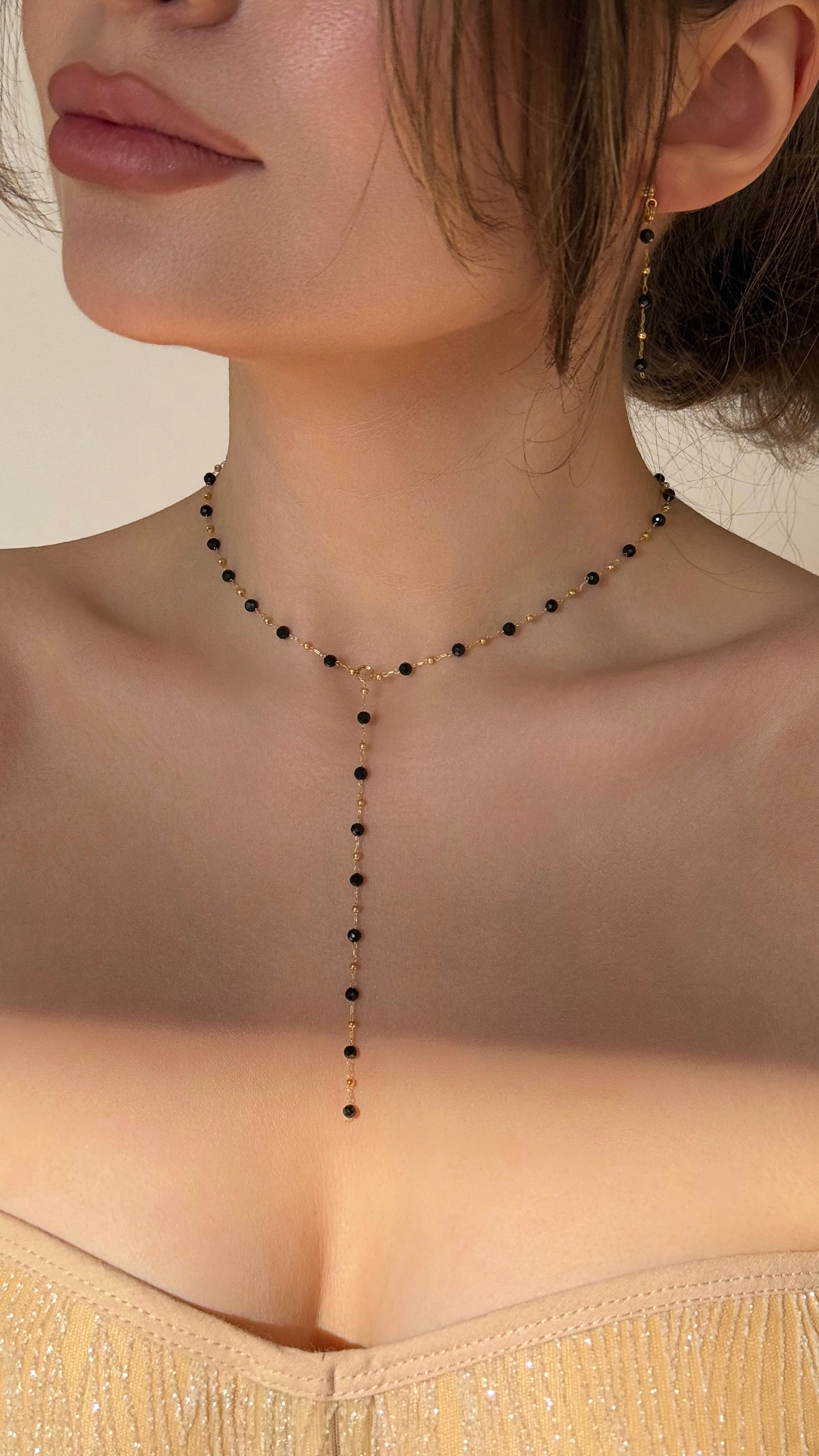 Close-up of a necklace on a person with a neutral background
