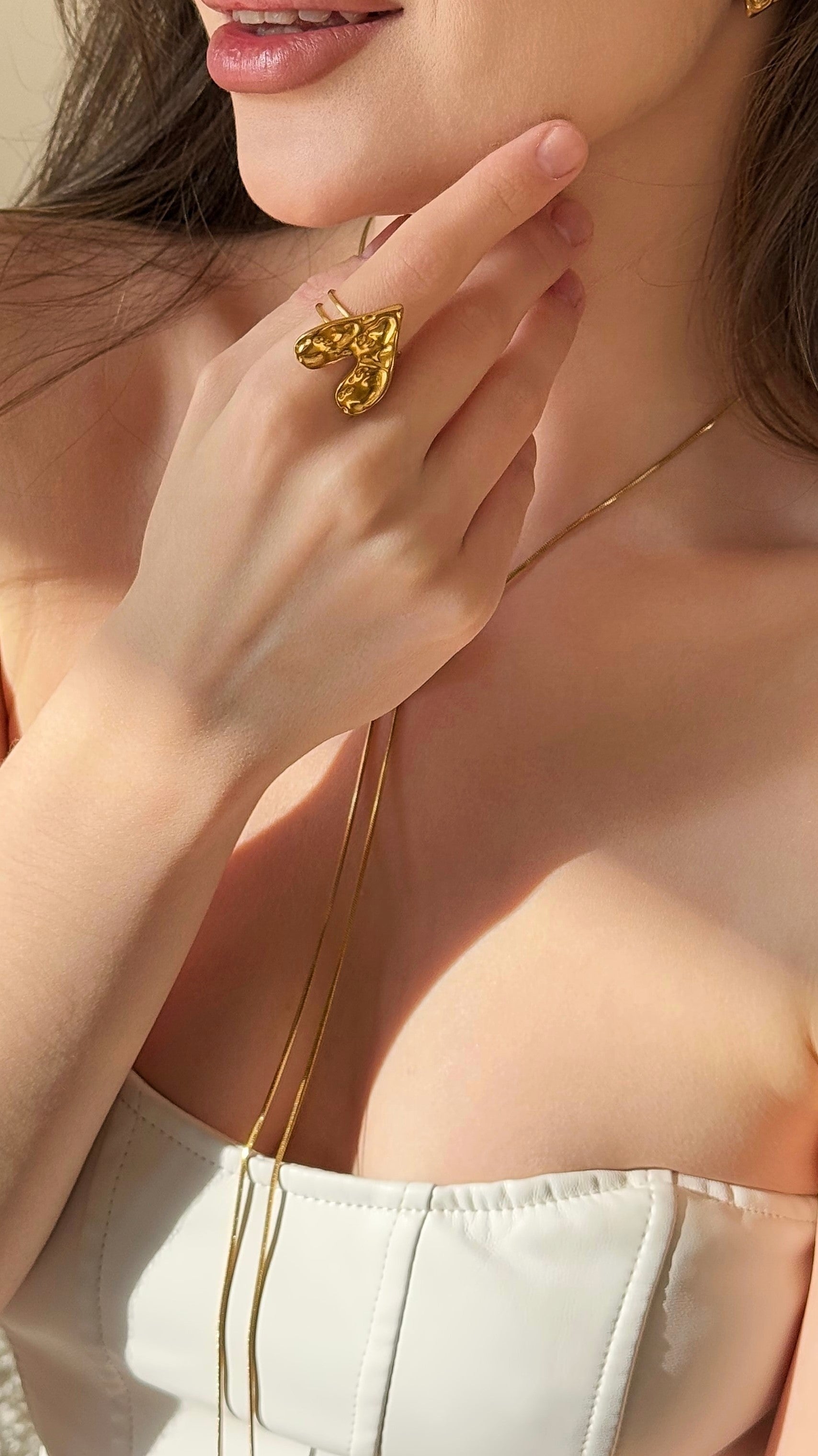 Close-up of a person wearing a gold-plated ring, with a soft focus on the background.