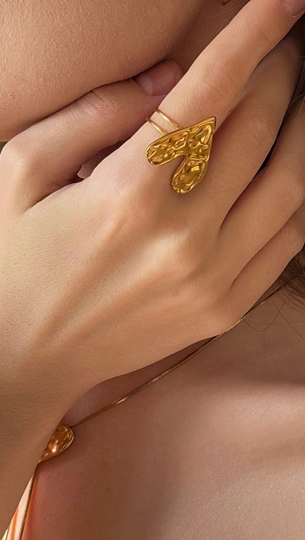 Gold-plated ring on a hand with a soft focus background