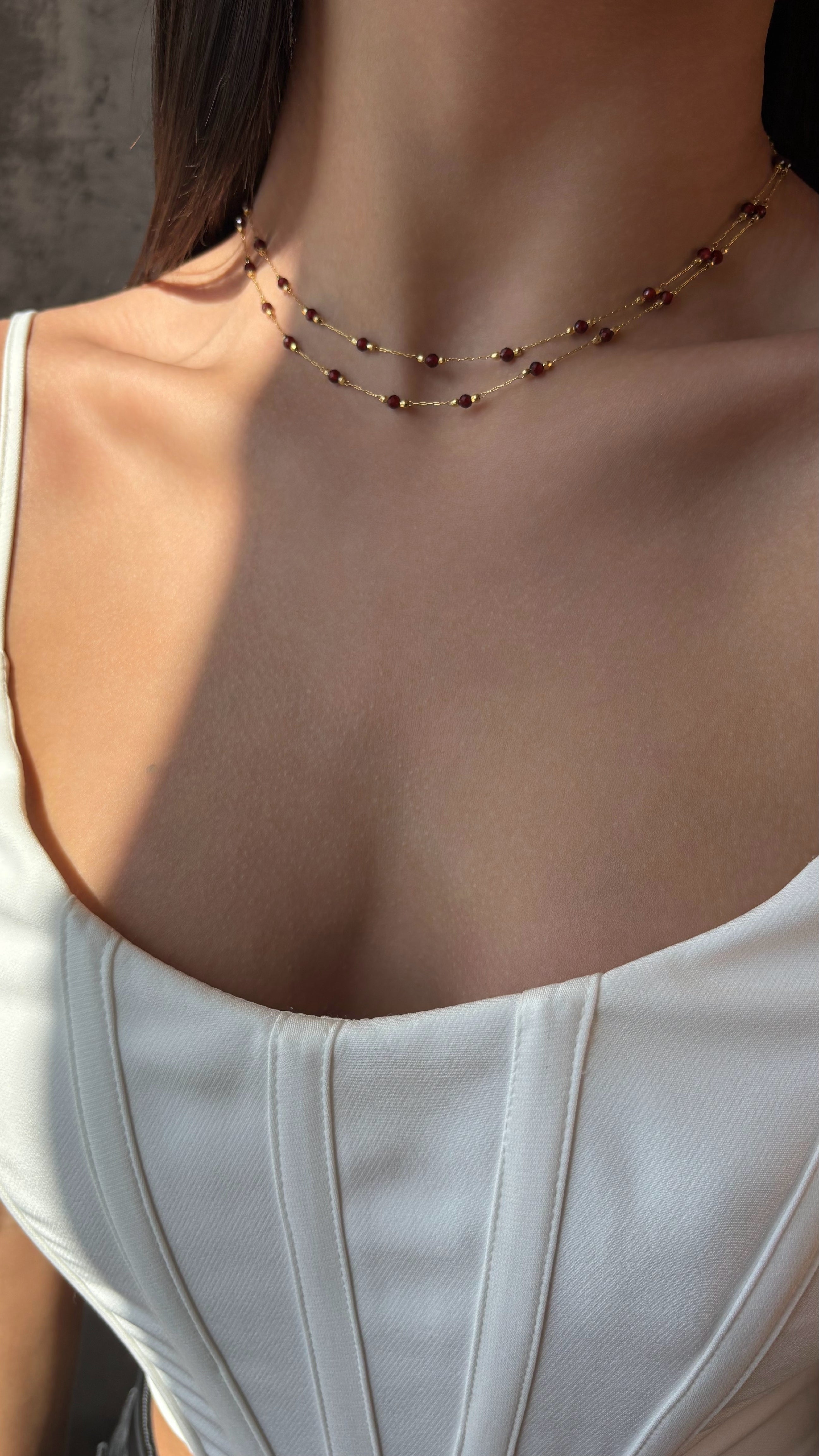 Necklace with red garnet worn by a person