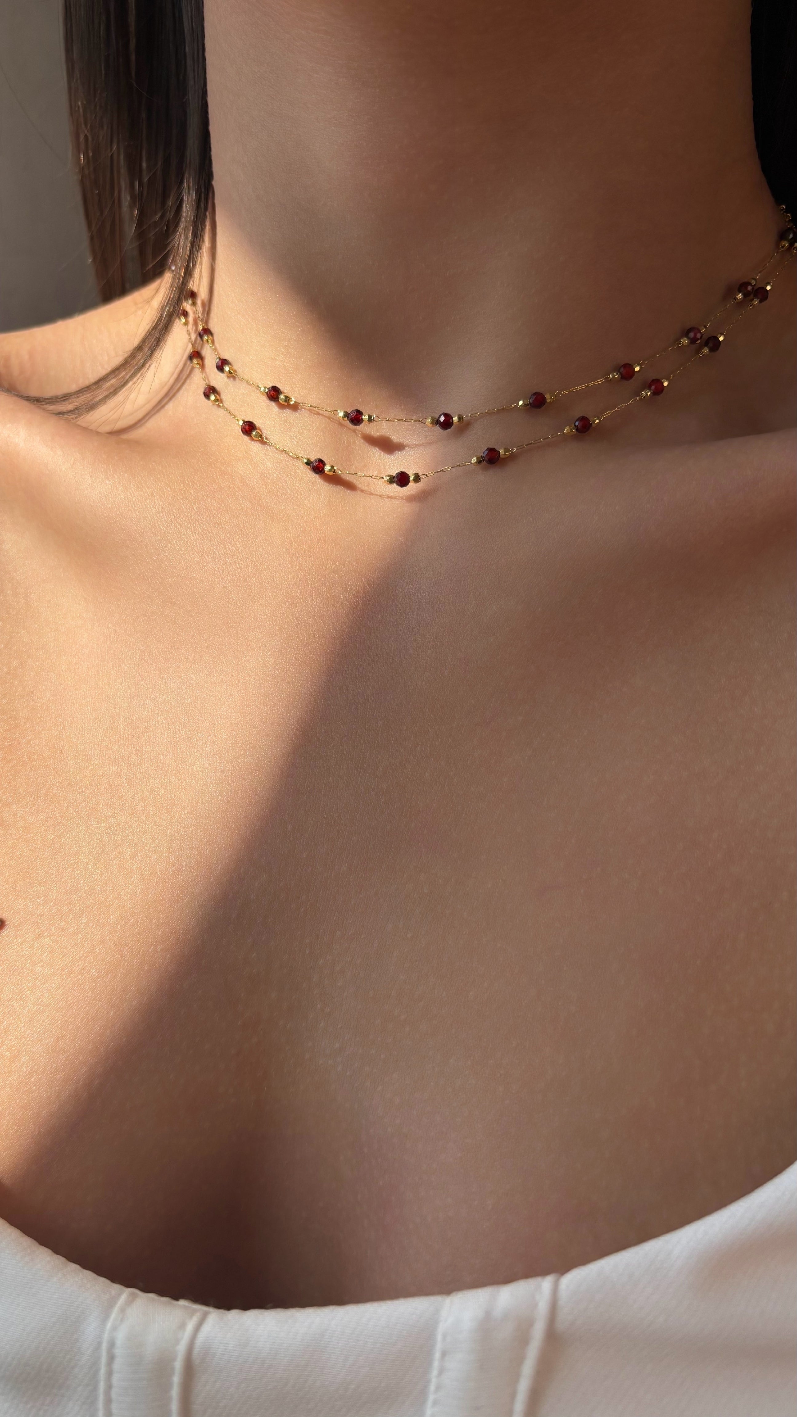 Necklace with red garnet worn by a person