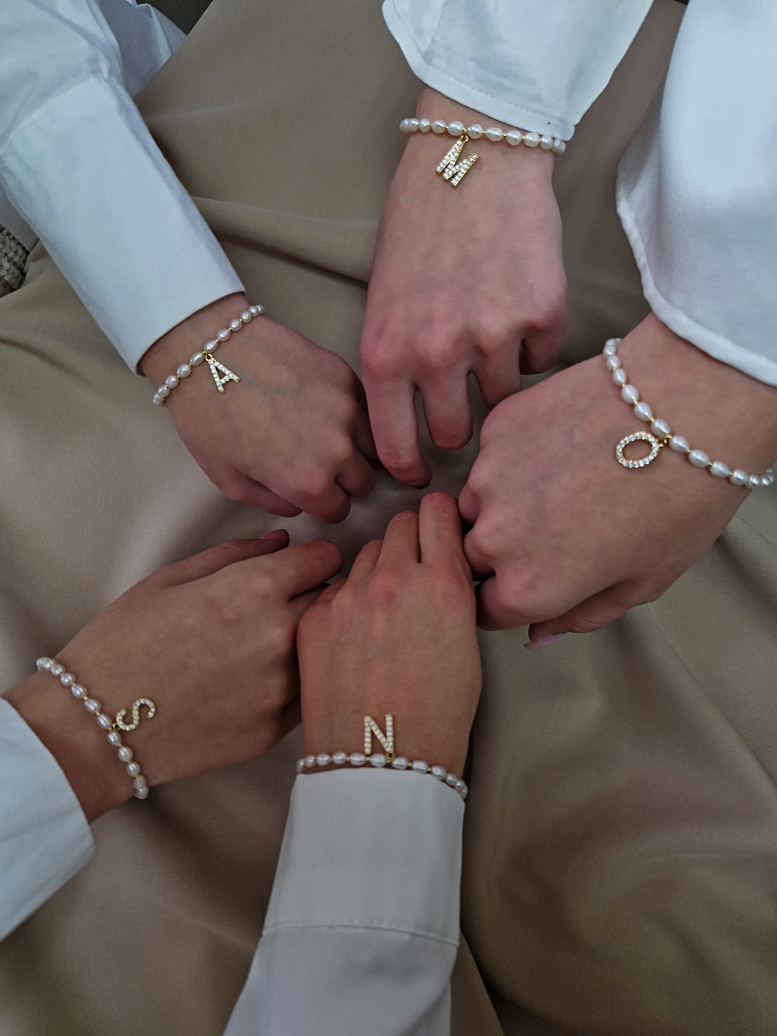 Personalized freshwater pearl bracelet with golden-plated initial charm adorned with sparkling cubic zirconia — delicate and feminine accessory perfect as a meaningful gift for bridesmaids at bachelorette parties or weddings, celebrating individuality and special bonds.