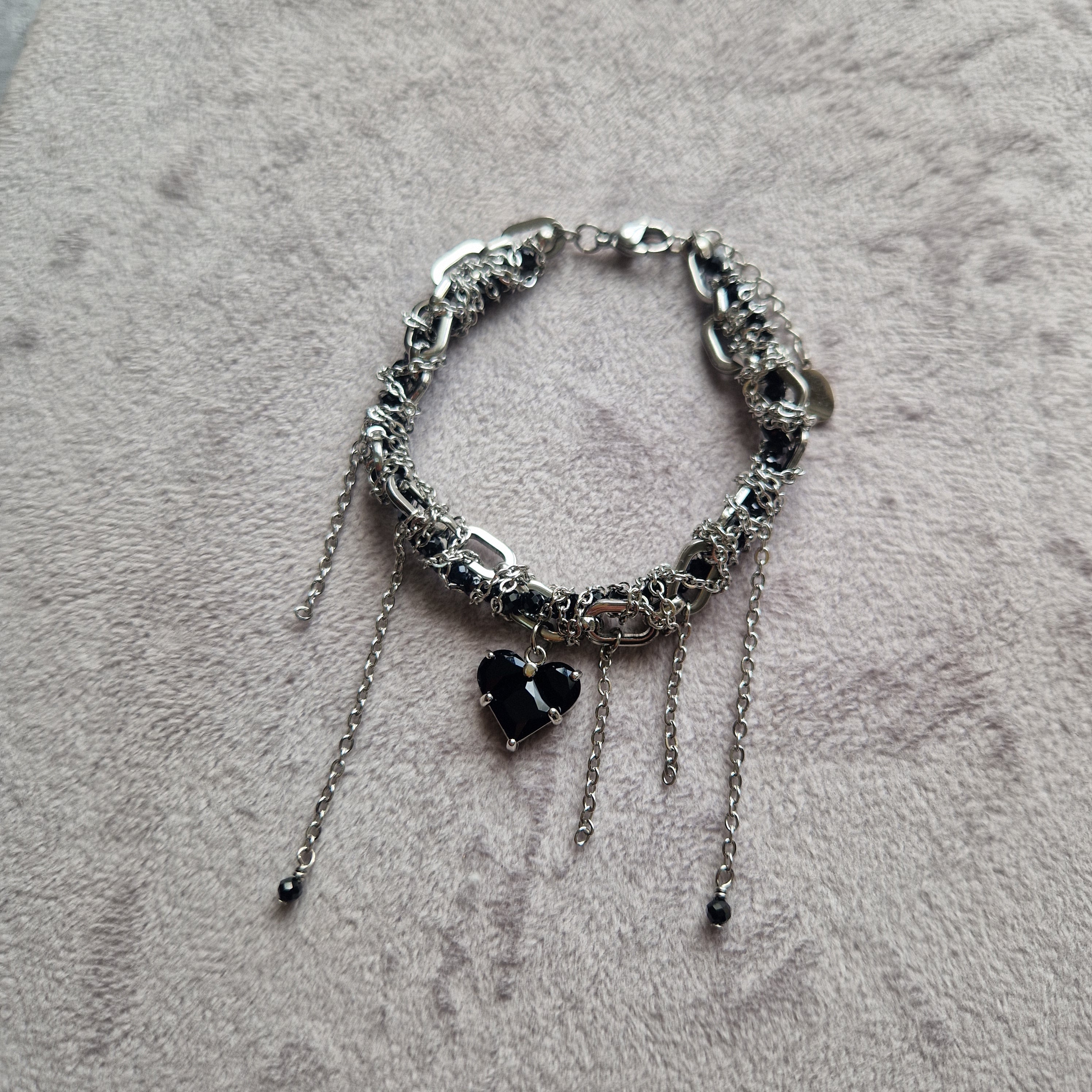 Silver bracelet with black beads on a textured gray surface