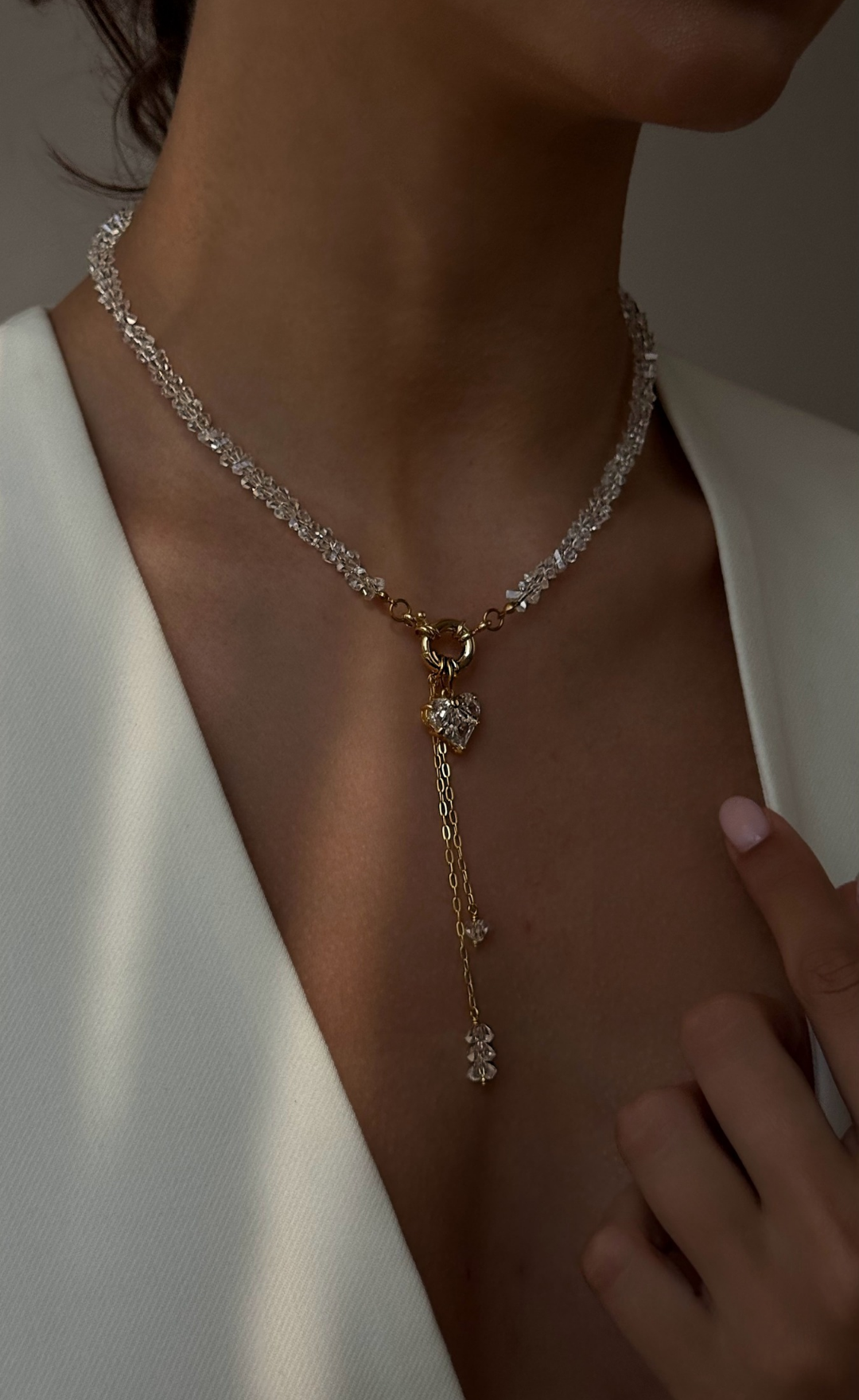 Close-up of a person wearing a delicate necklace with a white background