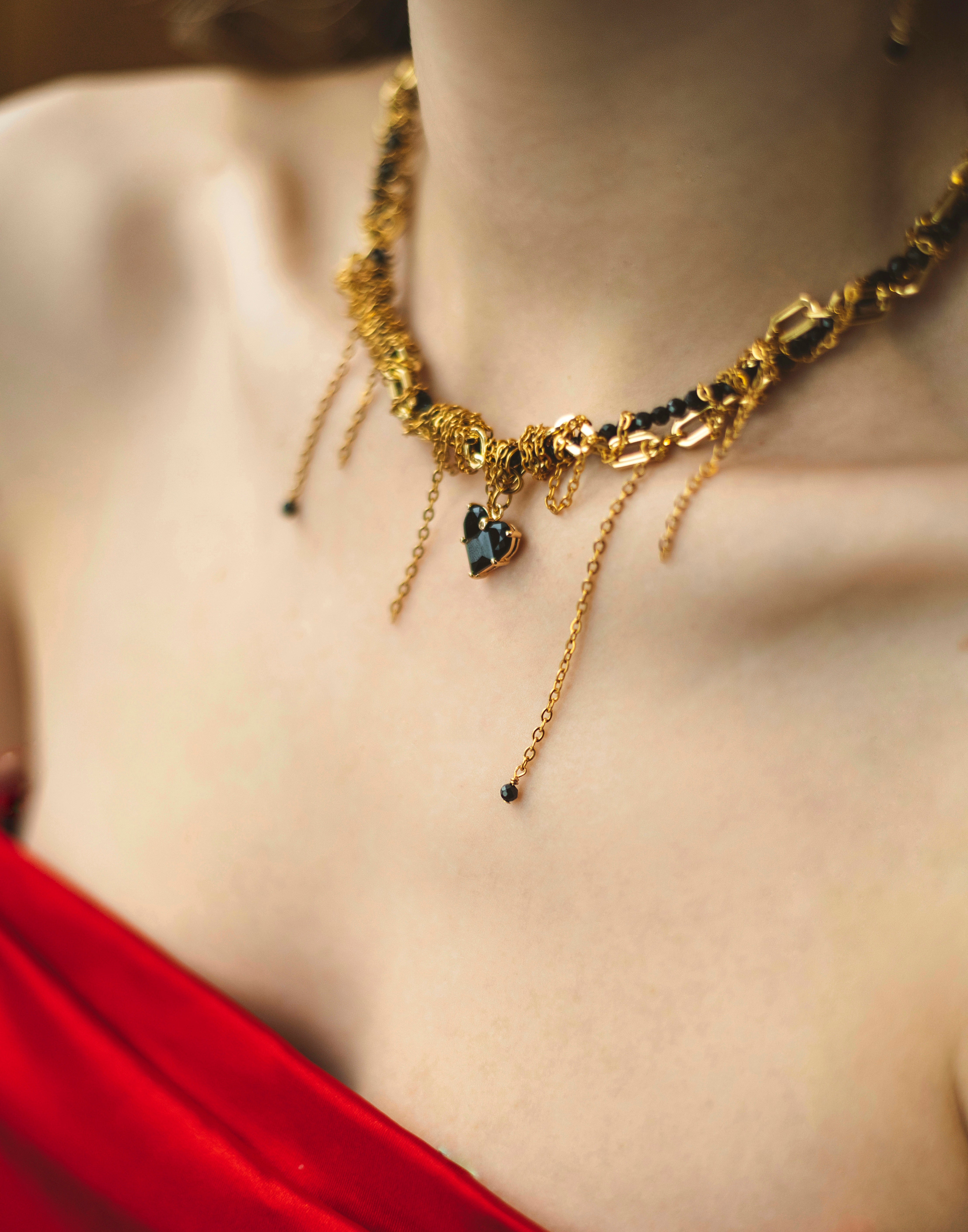 Gold-plated necklace with heart-shaped pendant on a blurred background