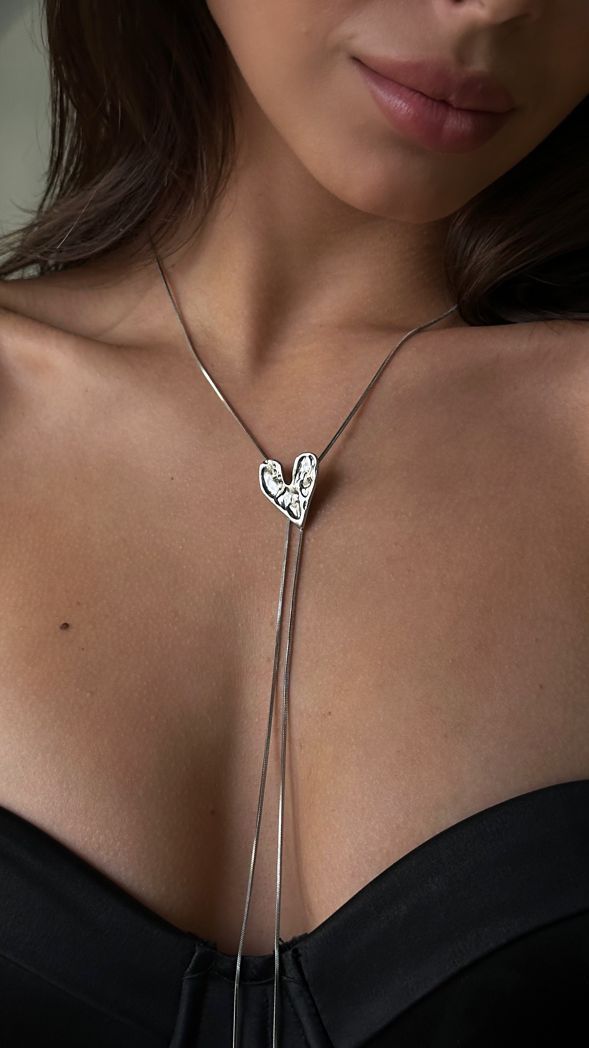 Sleek silver-tone lariat necklace with stainless steel beads in varying sizes, offering a minimalist and contemporary accent for both casual and elegant looks.