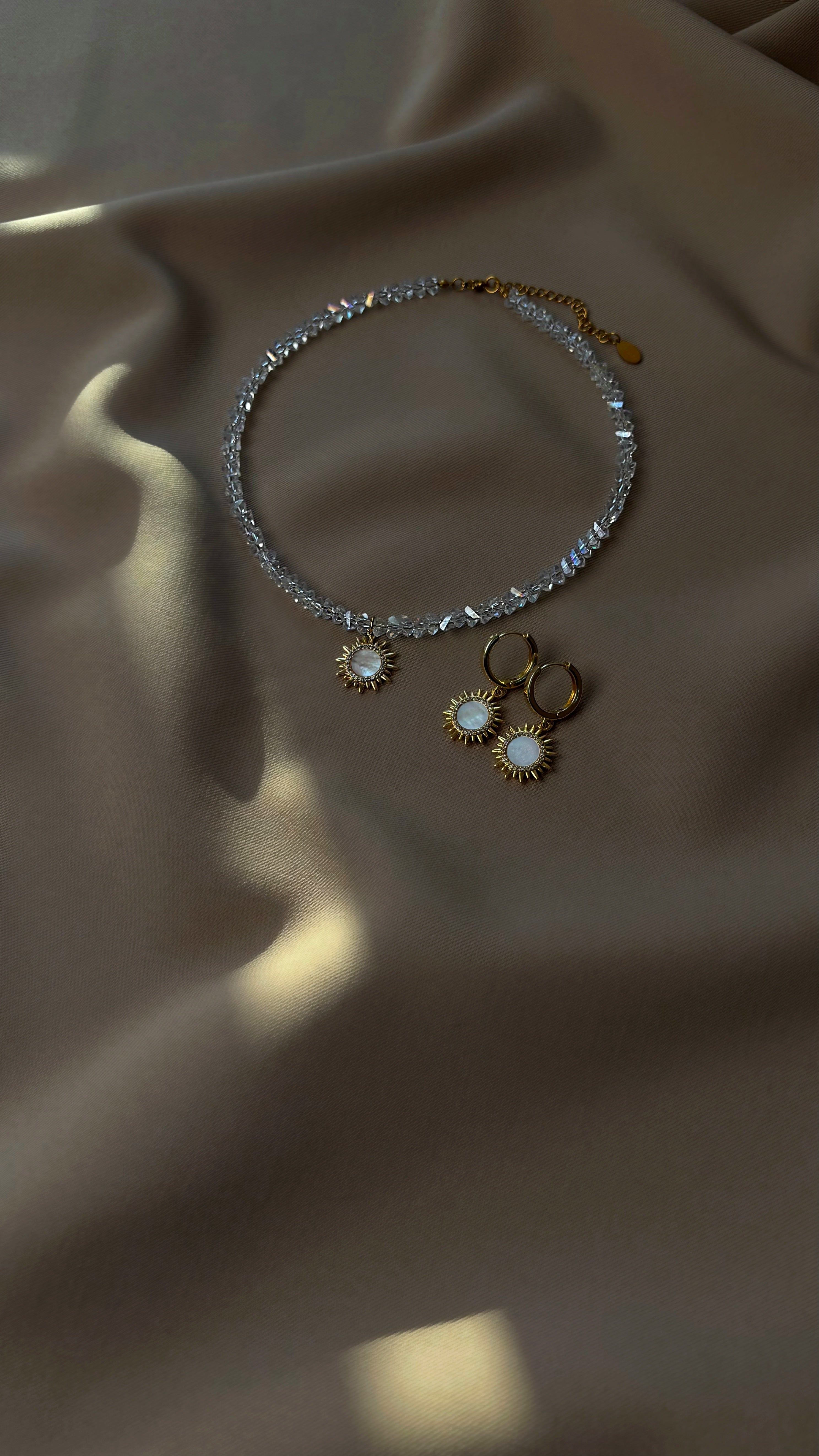Choker and earrings on a beige fabric background