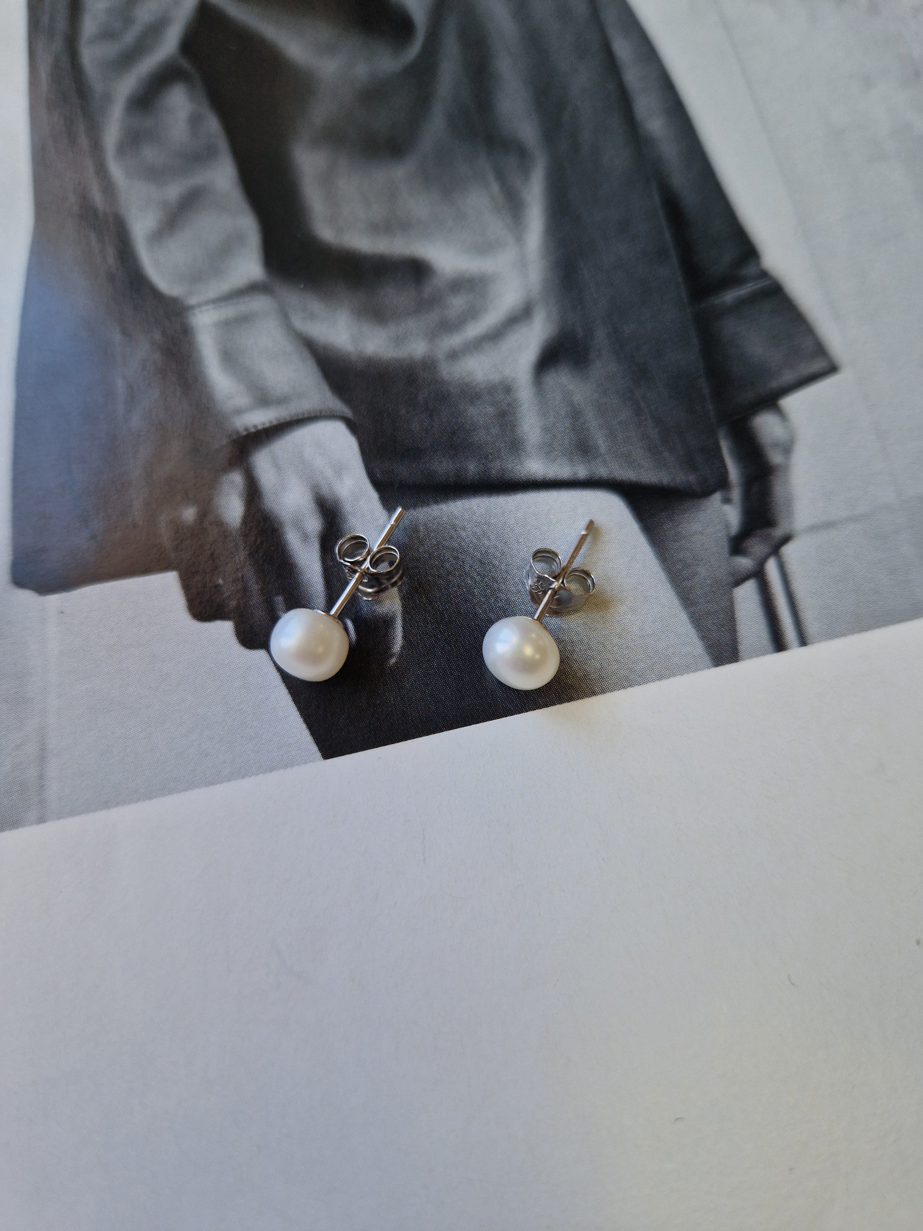 Delicate pearl stud earrings with a minimalist design, offering timeless elegance and lightweight comfort for everyday wear.
