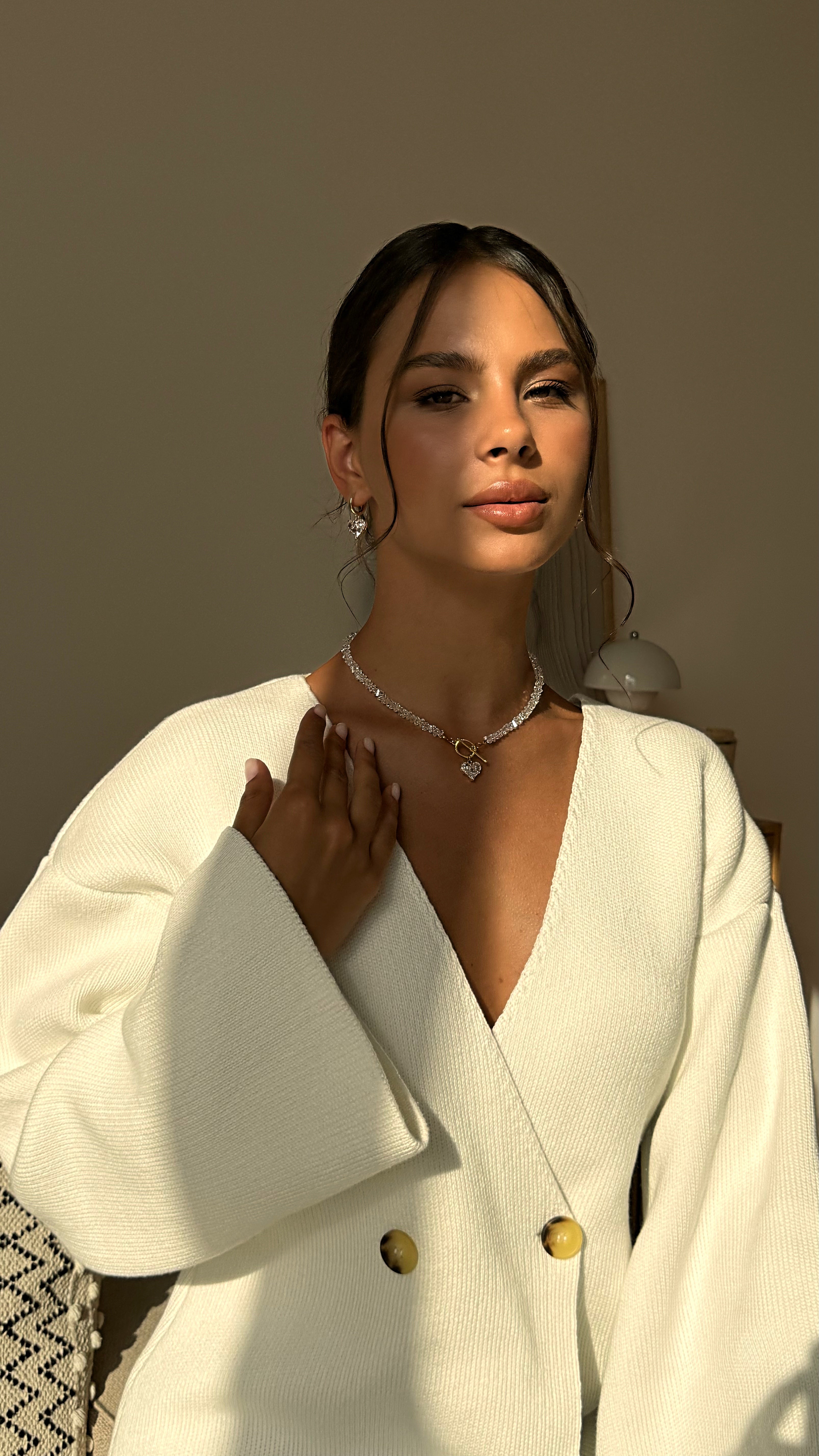 Jewelry set with necklace and earrings on a beige fabric background