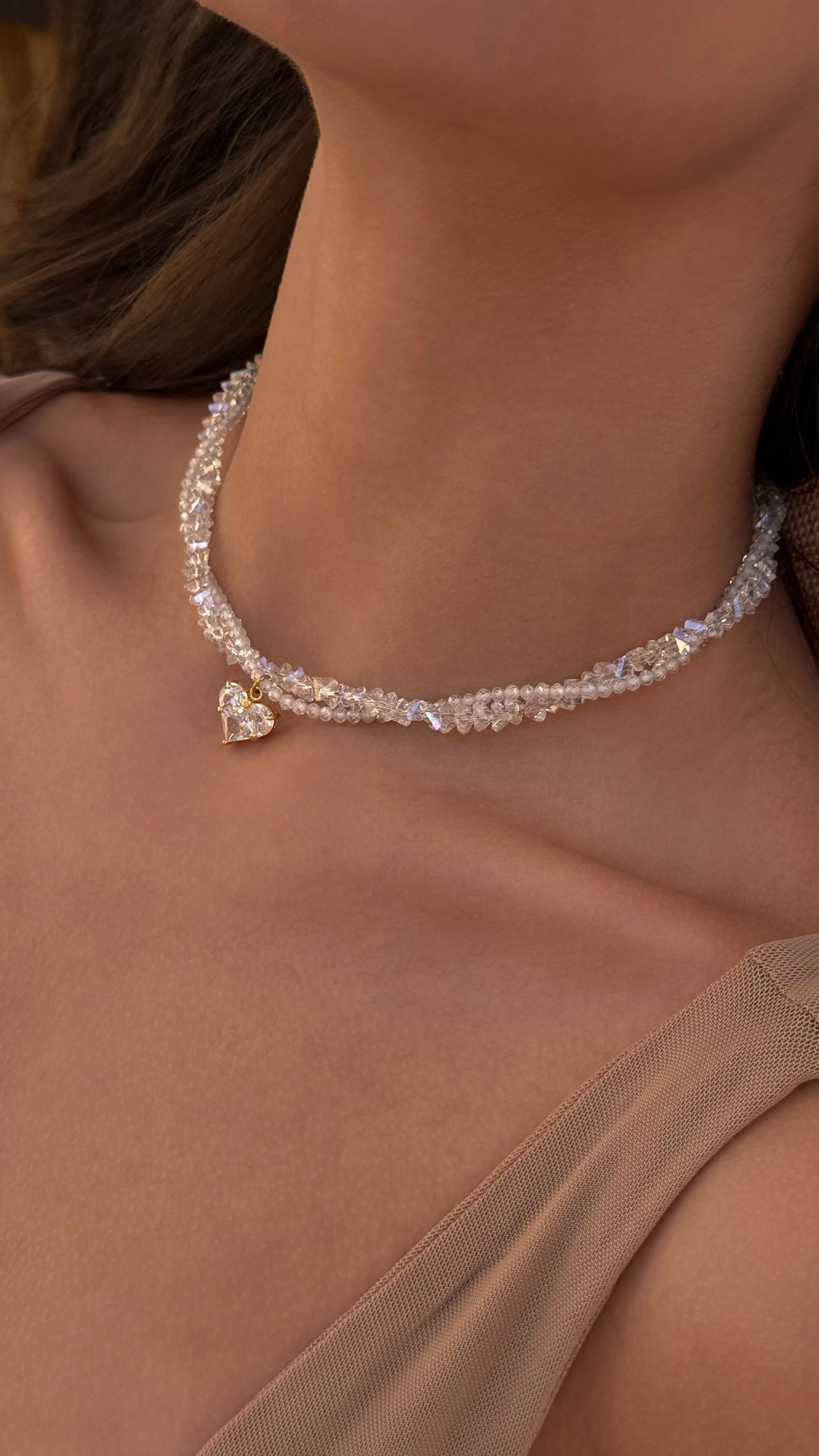 Necklace with a heart-shaped pendant worn by a person