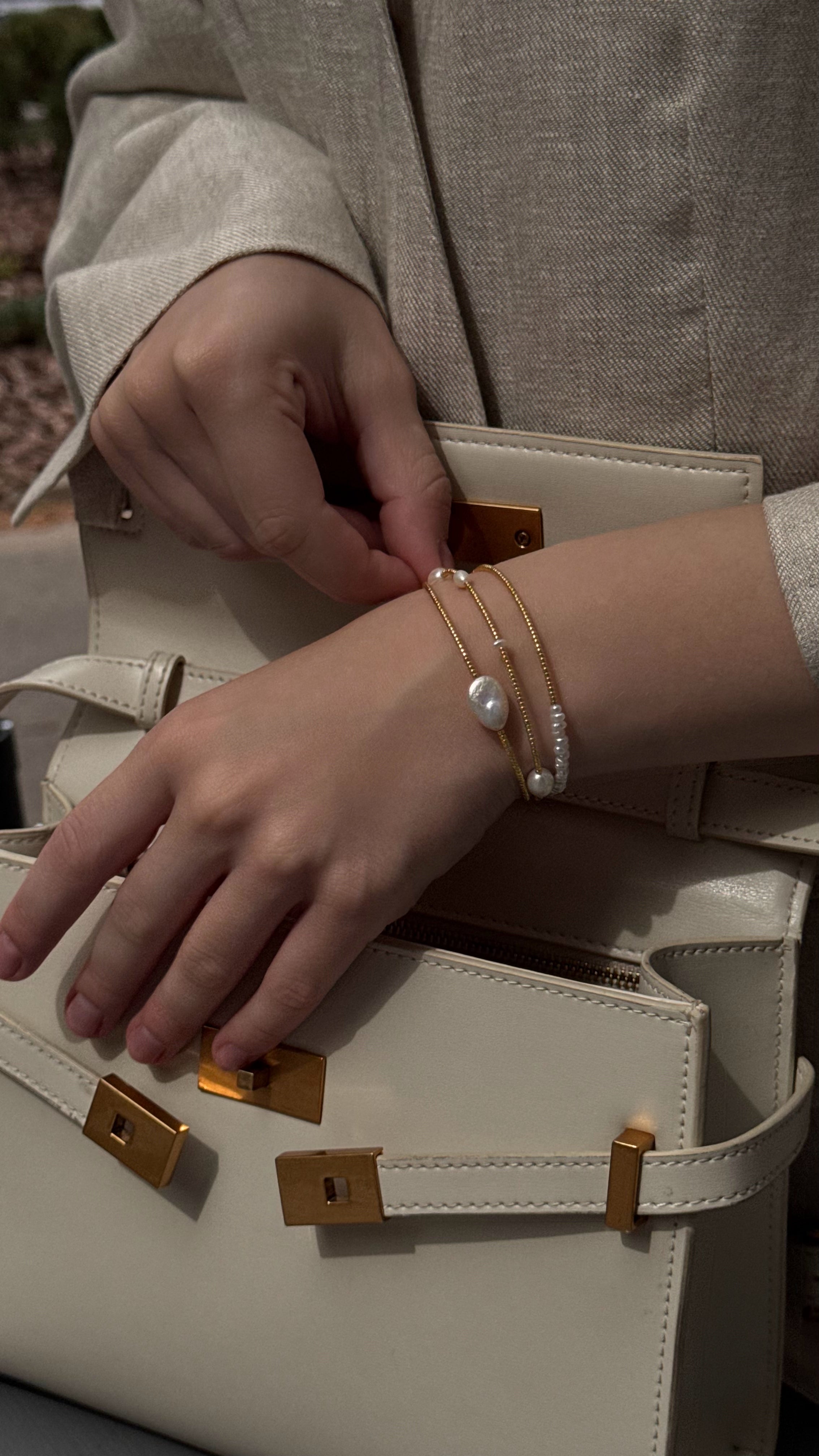 Triple-strand bracelet with Japanese seed beads and natural freshwater pearls in various shapes and sizes, featuring soft golden accents for an elegant and feminine look.