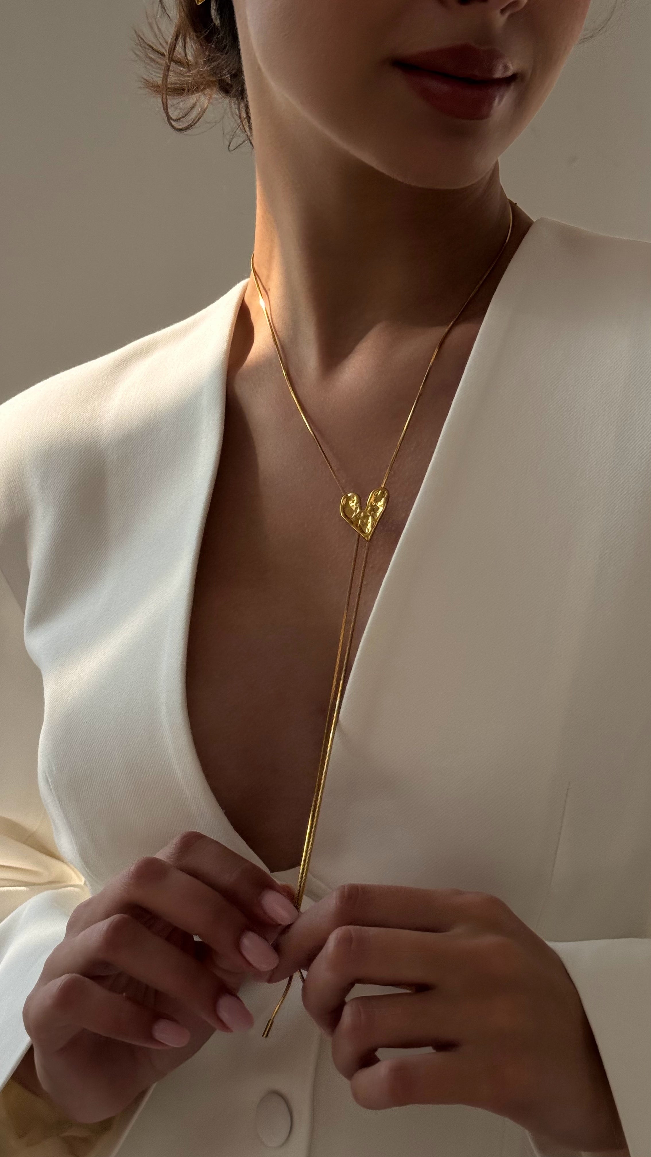 Elegant adjustable lariat necklace with a delicate heart pendant, crafted from gold-tone stainless steel, featuring a sliding design for customizable length — perfect for layering or wearing solo.