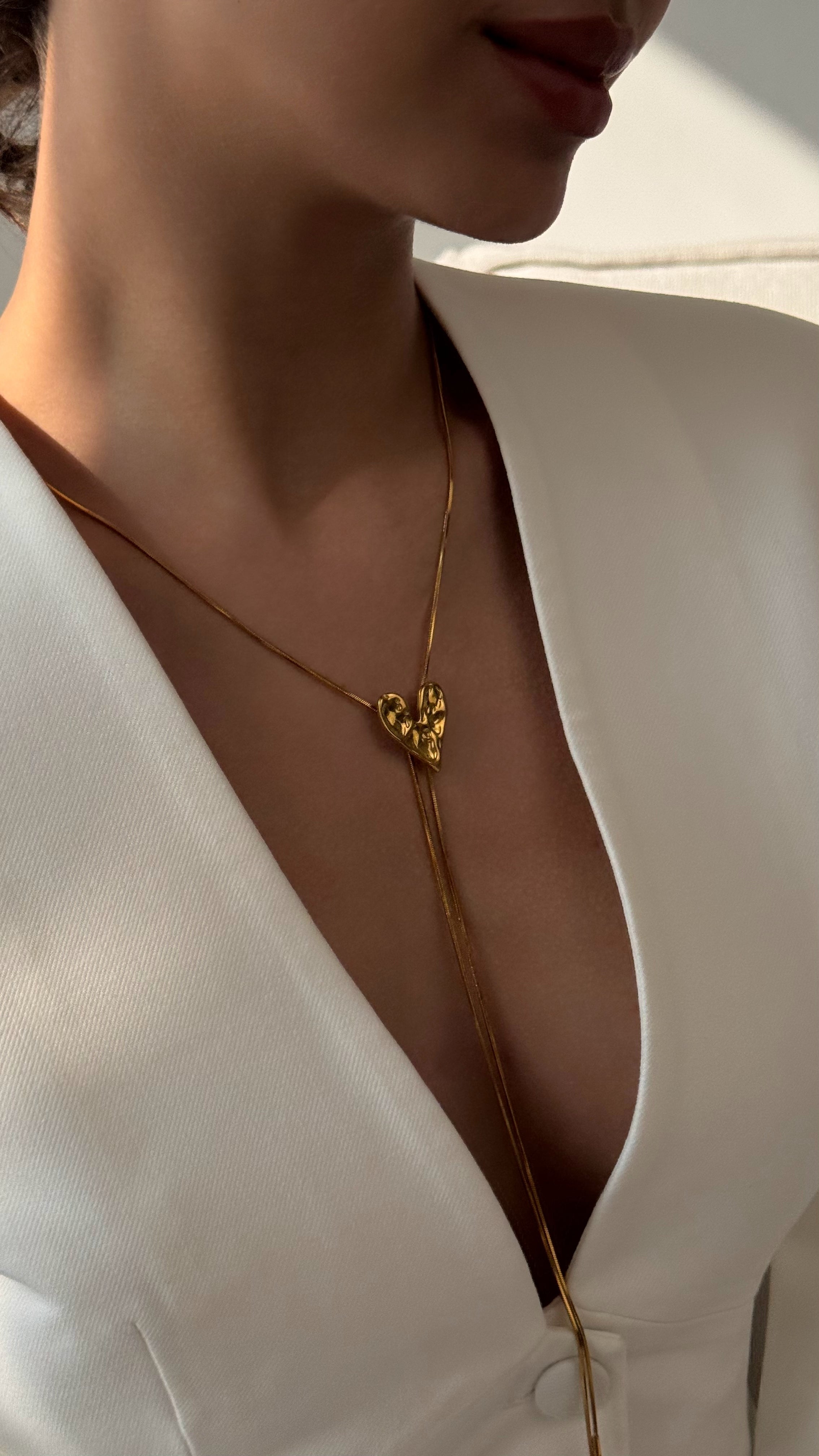 Elegant adjustable lariat necklace with a delicate heart pendant, crafted from gold-tone stainless steel, featuring a sliding design for customizable length — perfect for layering or wearing solo.