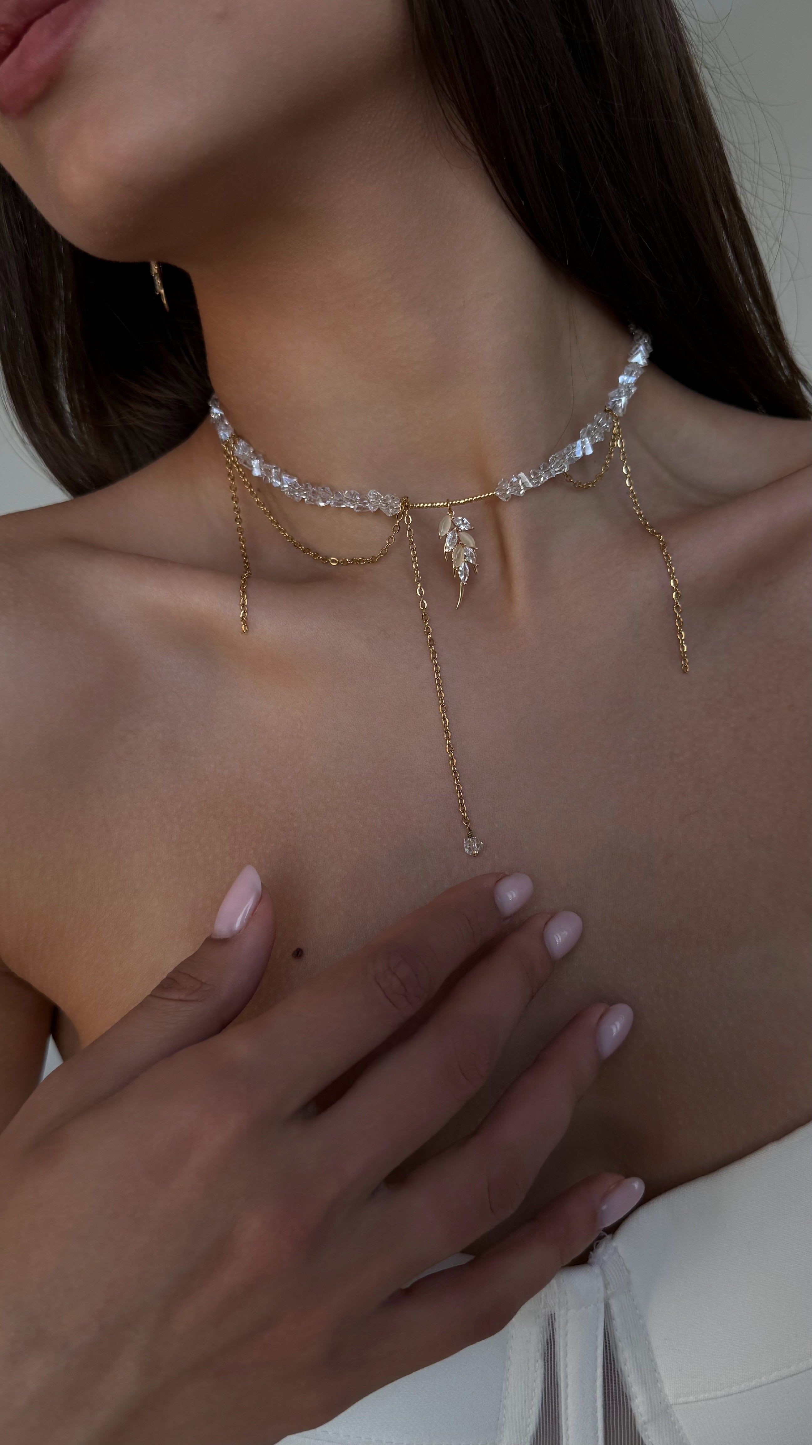 Close-up of a woman wearing a delicate gold-plated necklace with a blurred background