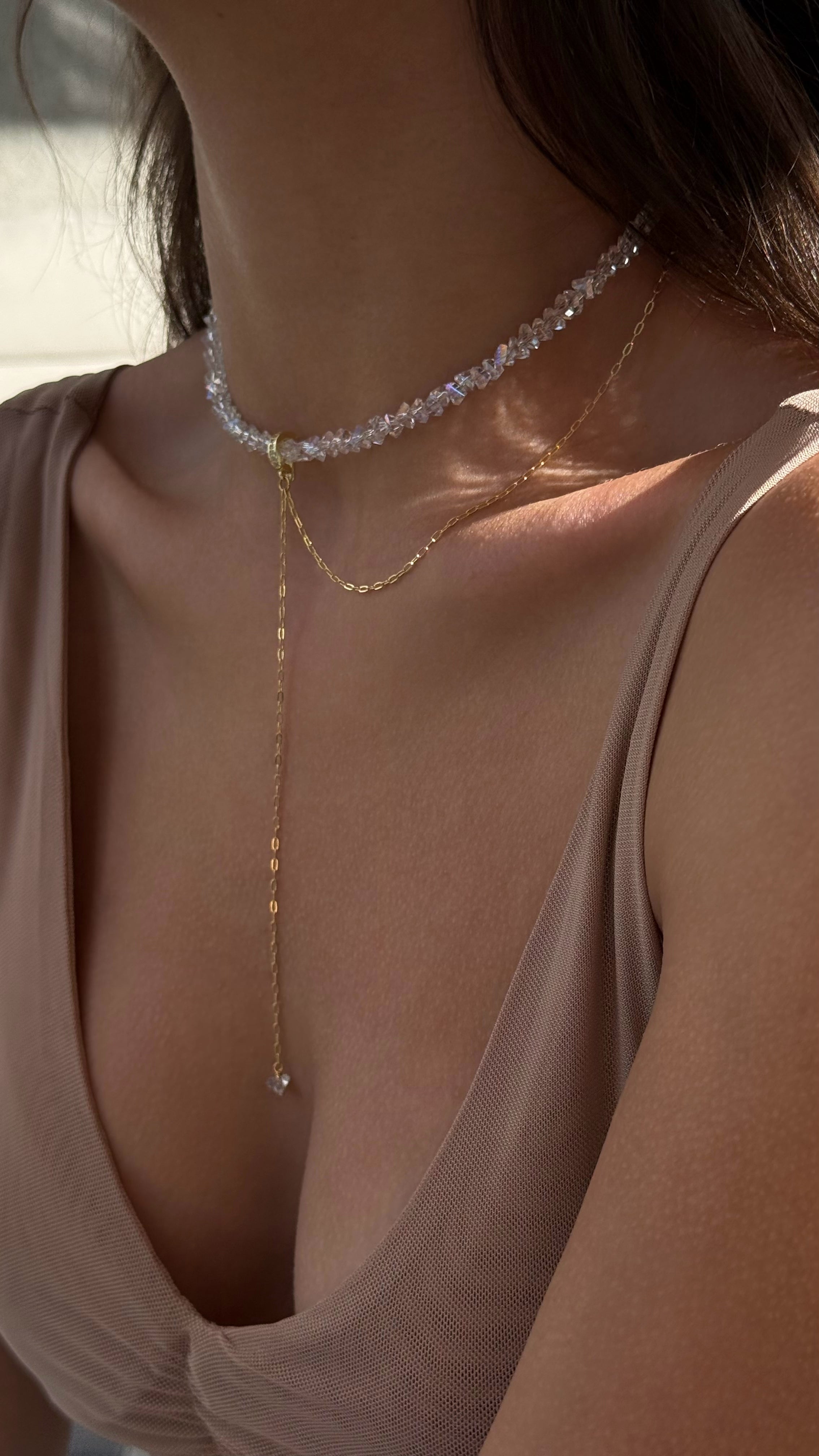 Close-up of a person wearing necklaces with a blurred background